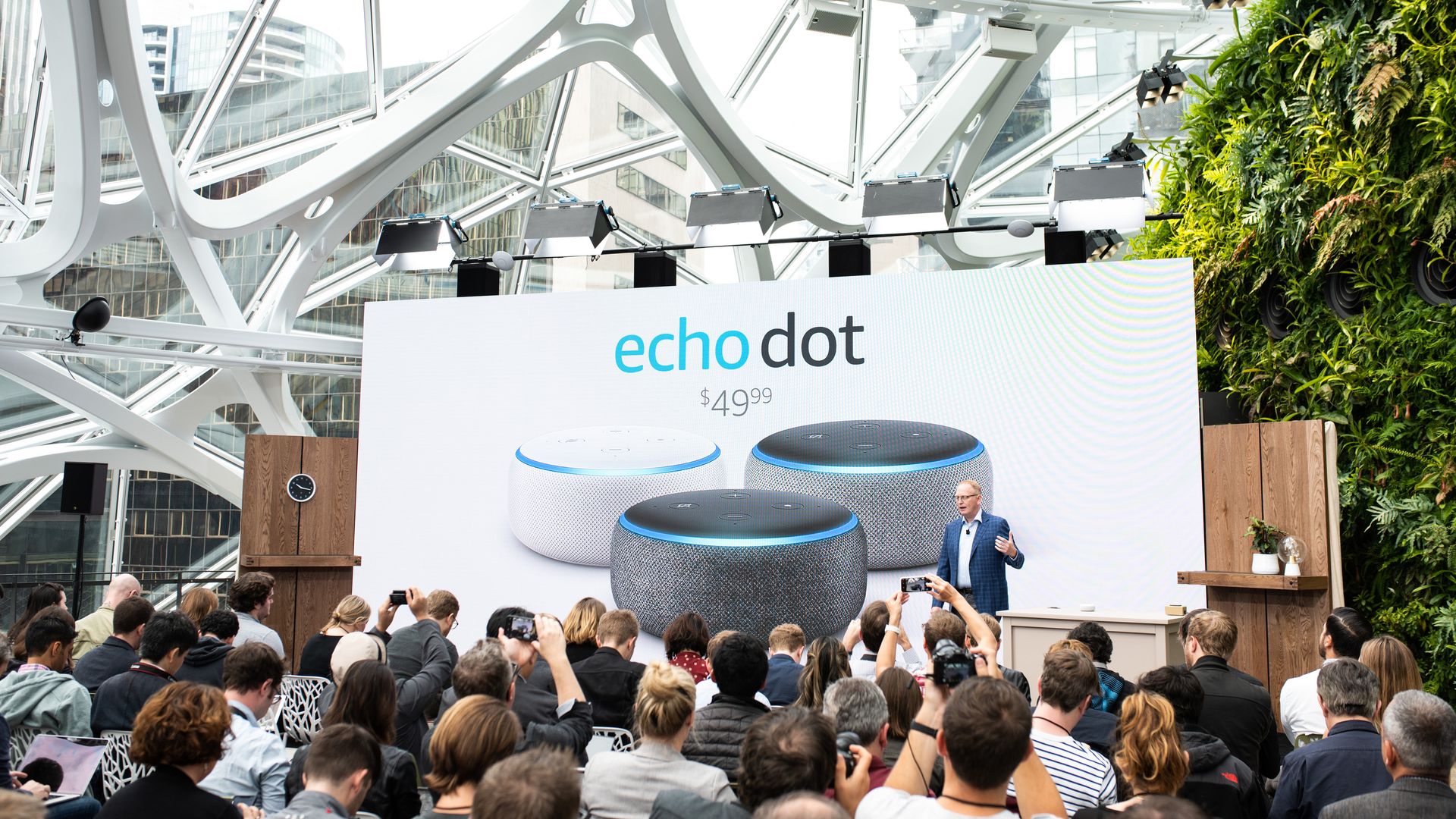 In this image, a crowd surrounds a stage that supports a large Amazon Echo Dot advertisement.