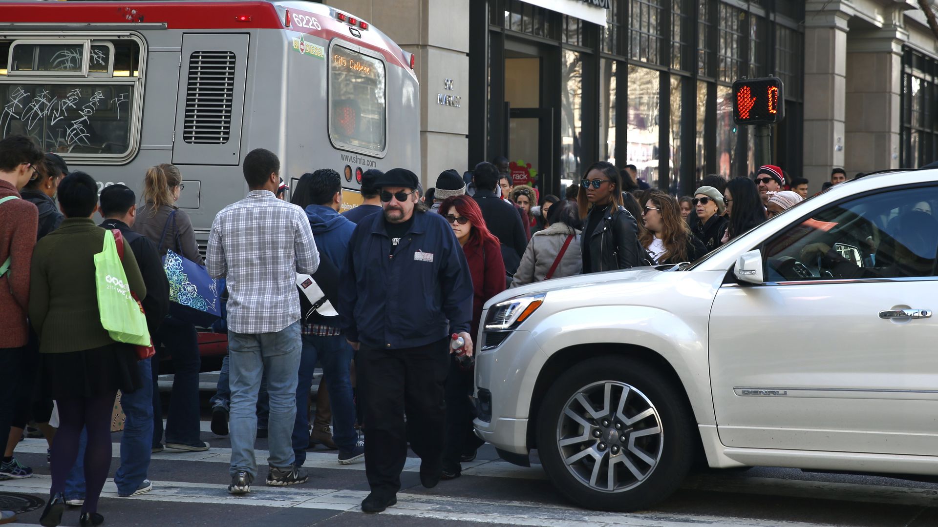 Pedestrians walk between vehicles blocking the crosswalk and intersection at Fifth and Market streets in San Francisco. Photo: Paul Chinn/The San Francisco Chronicle via Getty Images