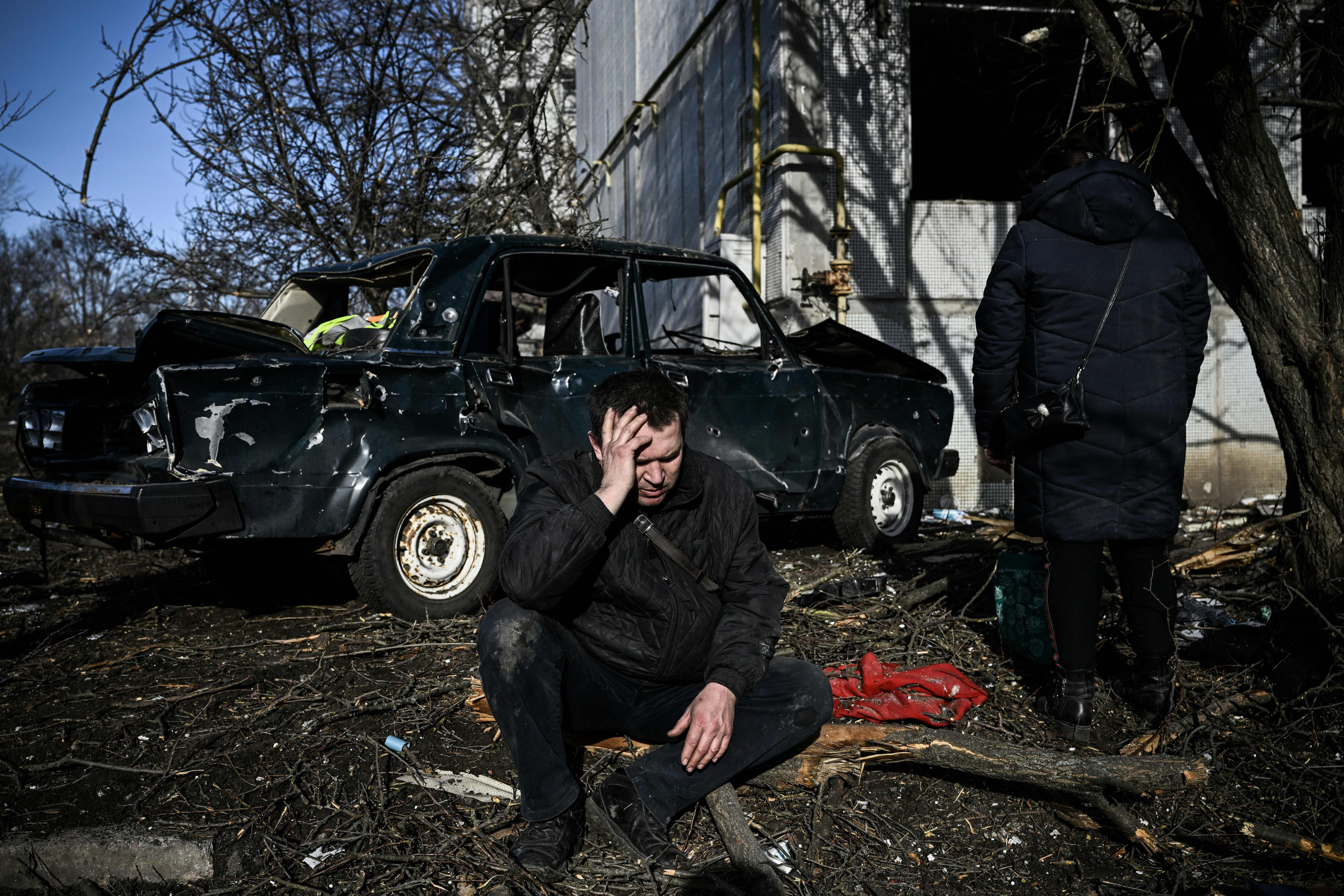 A man sits outside his destroyed building after bombings on the eastern Ukraine town of Chuhuiv on Feb. 24.