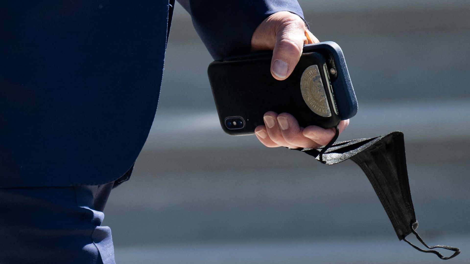 President Biden is seen carrying a mask and cellphone as he leaves the White House on Wednesday.