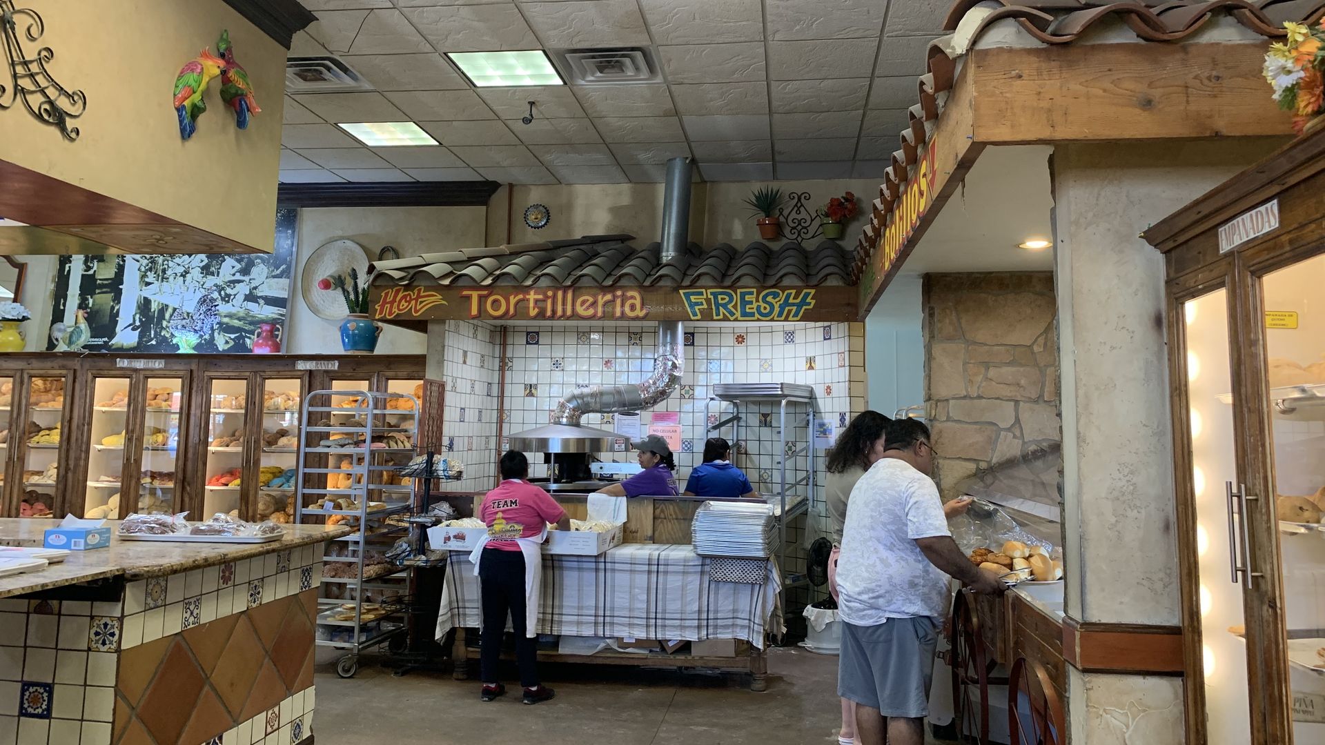 Photo of the inside of a Mexican bakery, with a sign for fresh tortilla and sweet breads. 