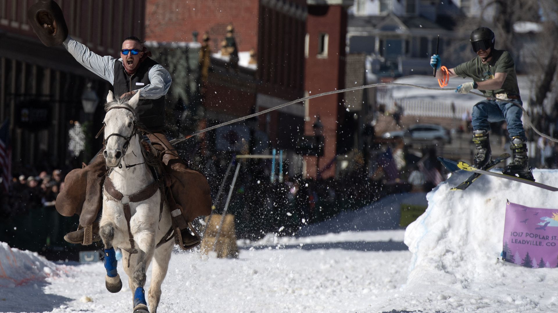 Rider Noah Gregory waves his cowboy hat towards spectators as he pulls a skier during the 2025 Leadville Ski Joring competition Photo: Jason Connolly/AFP via Getty Images