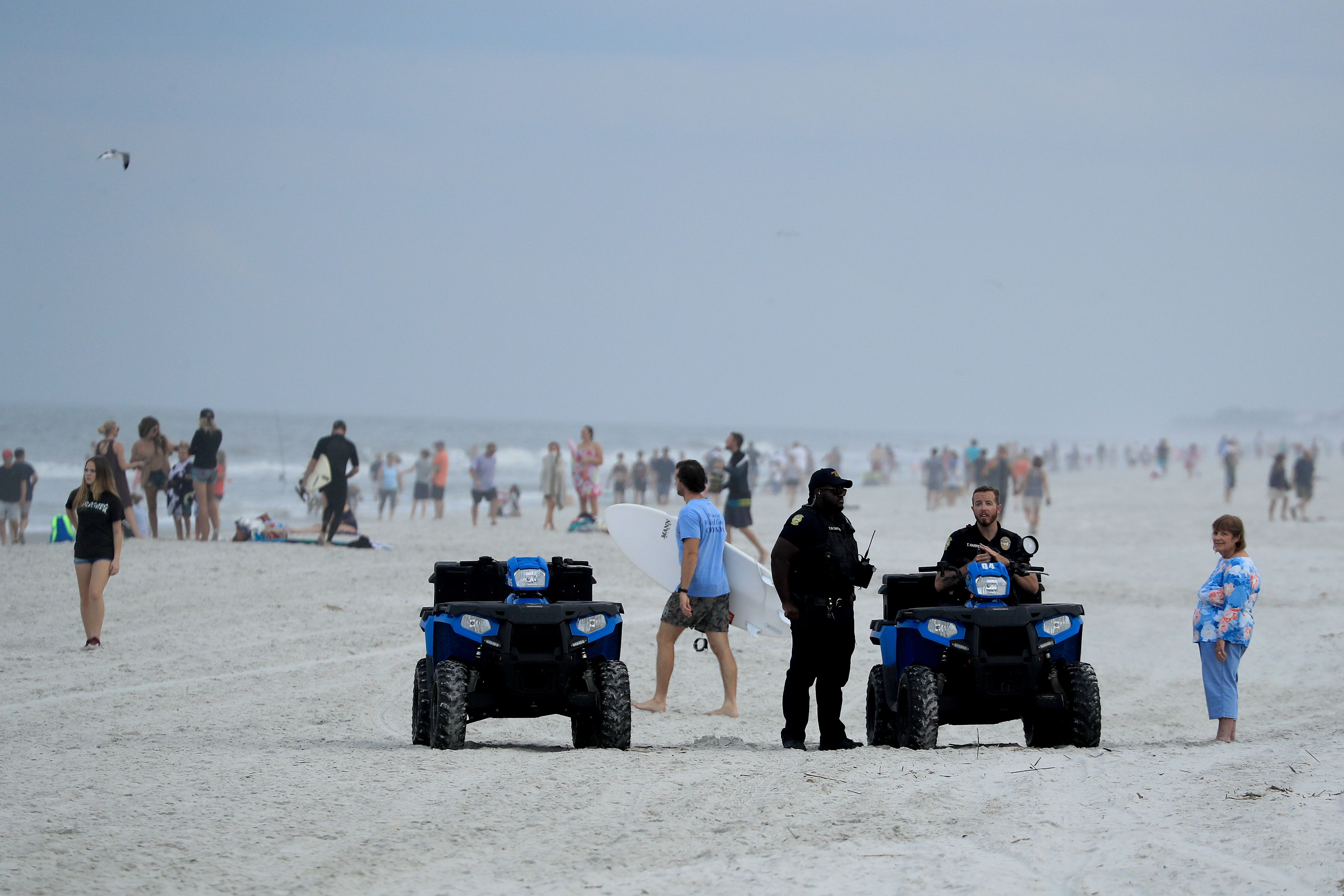 Police are seen speaking to people at the beach on April 19, 2020 in Jacksonville Beach, Florida. 