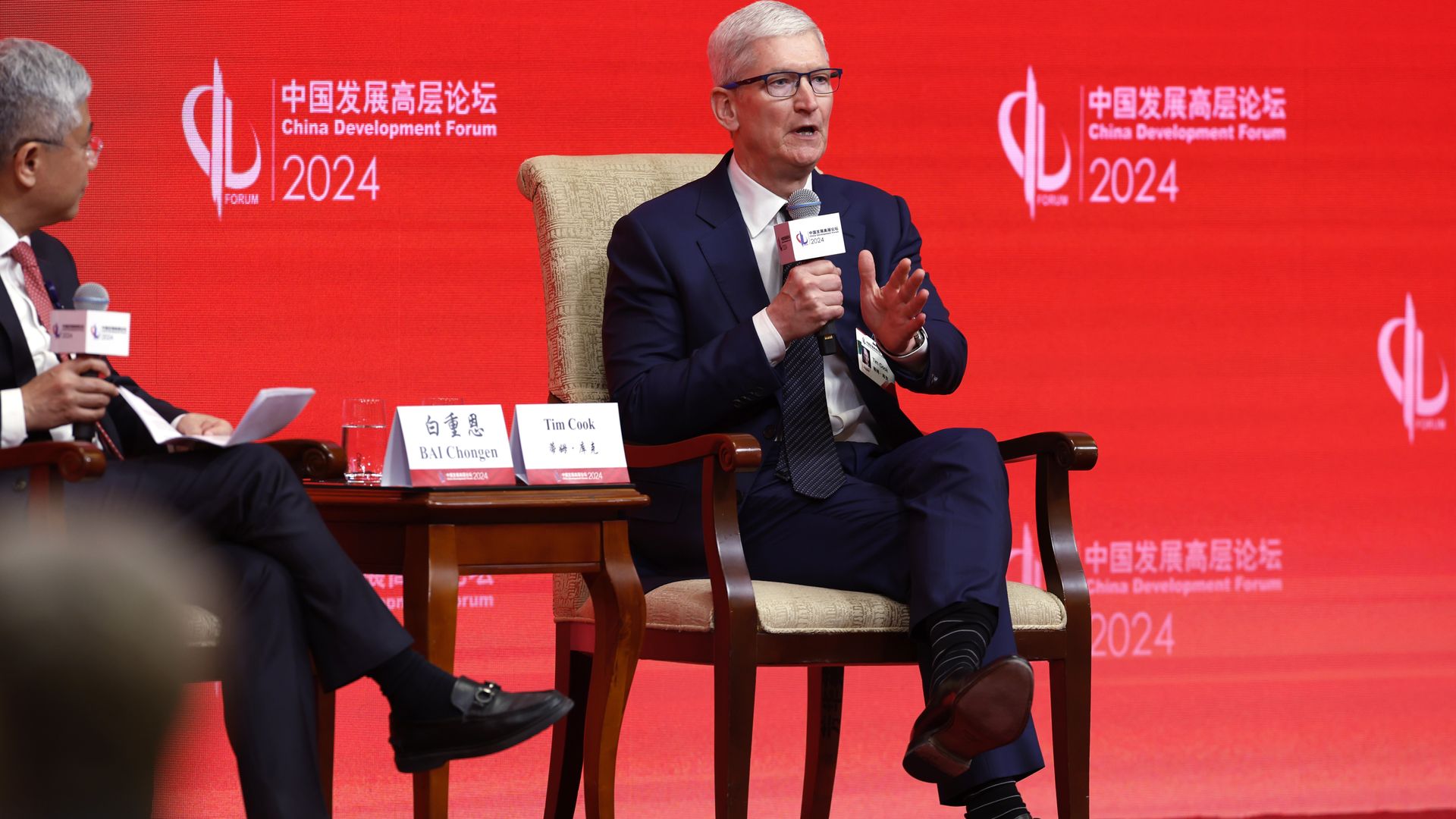 photo of Tim Cook sitting on a chair on stage against a red backdrop that says "China Development Forum 2024"