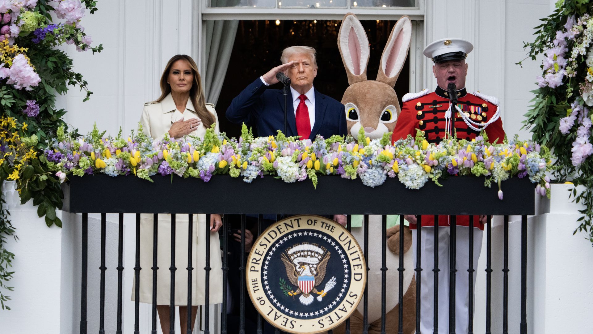 Donald and Melania Trump stand on the balcony of the White House with the Easter Bunny and a Marine Band singer.