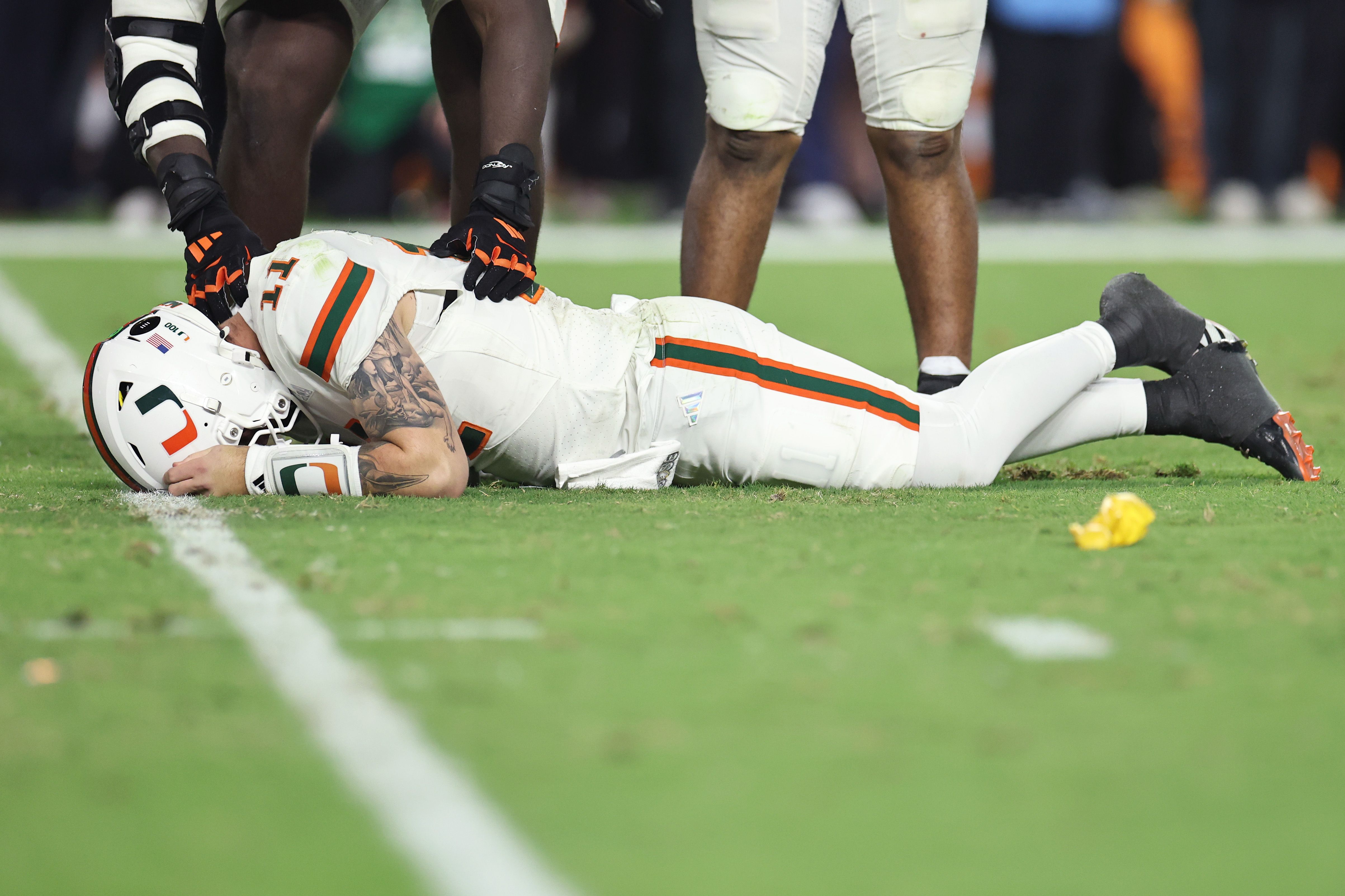 A UM football player laying on the floor face down. 