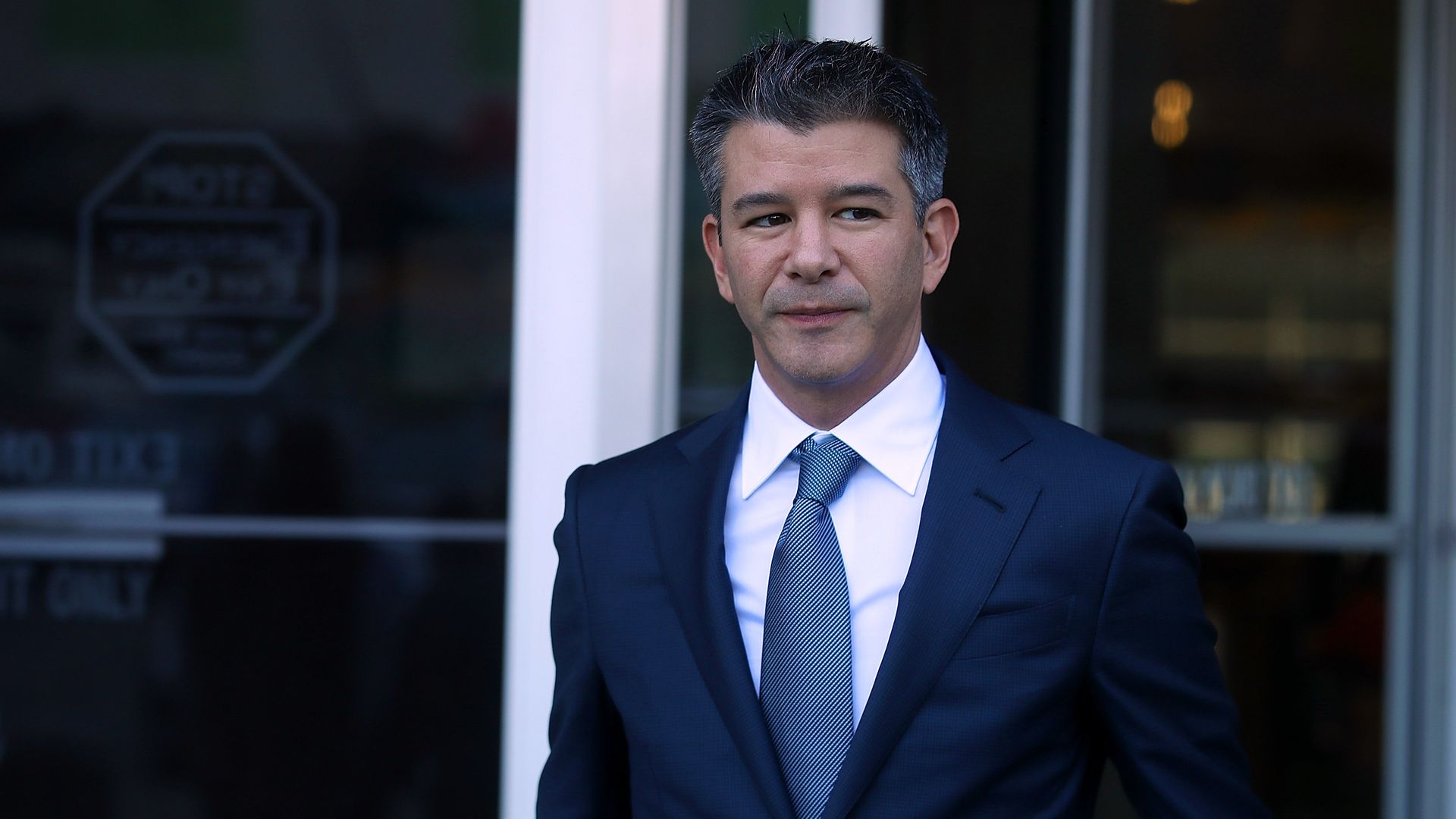 Former Uber CEO Travis Kalanick wearing a suit and tie