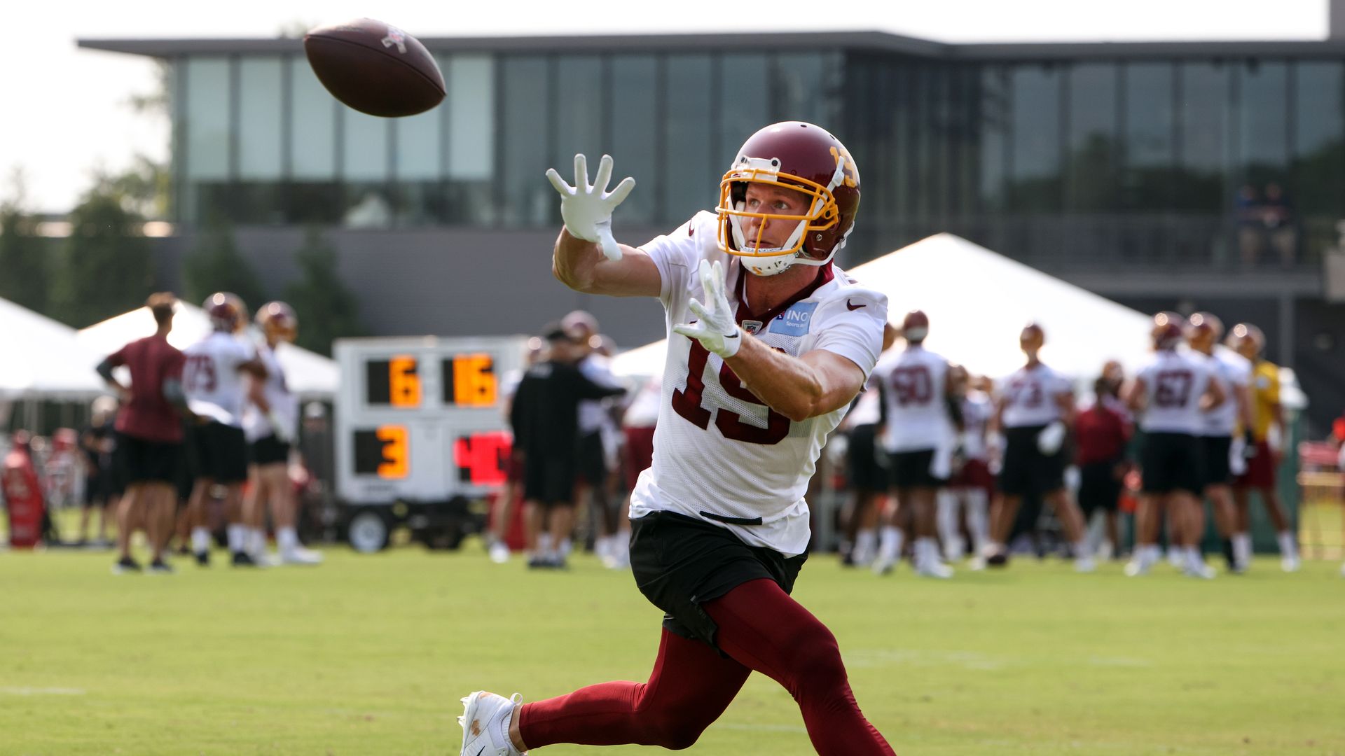 A football player catches a football at the Richmond training camp.