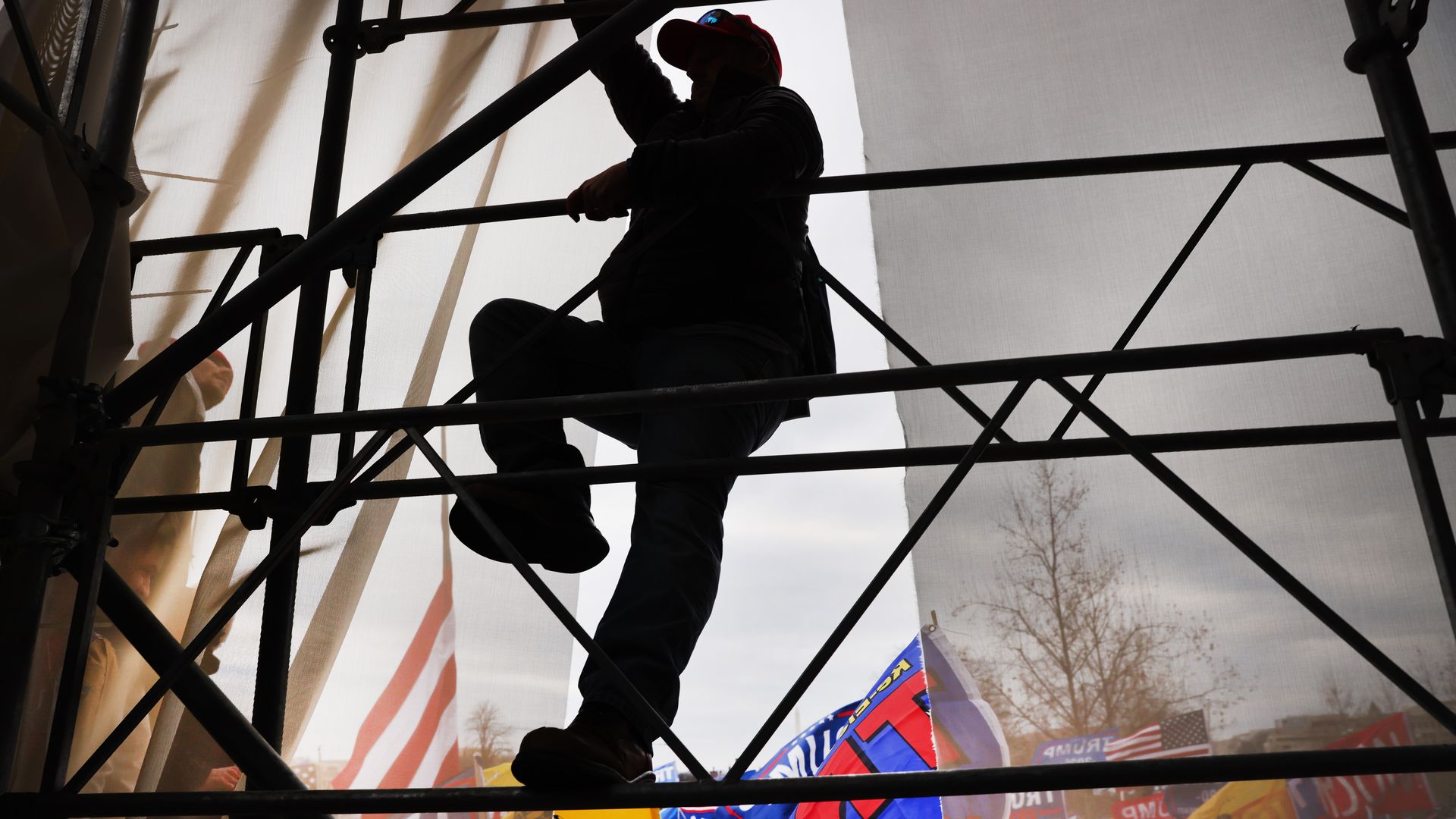 A protestor is seen scaling scaffolding outside the U.S. Capitol on Jan. 6, 2021.