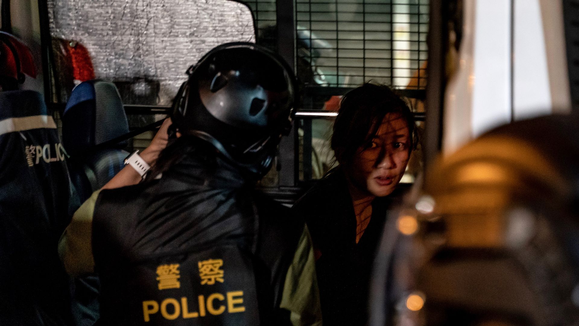 A pro-democracy protester being detained by riot police.