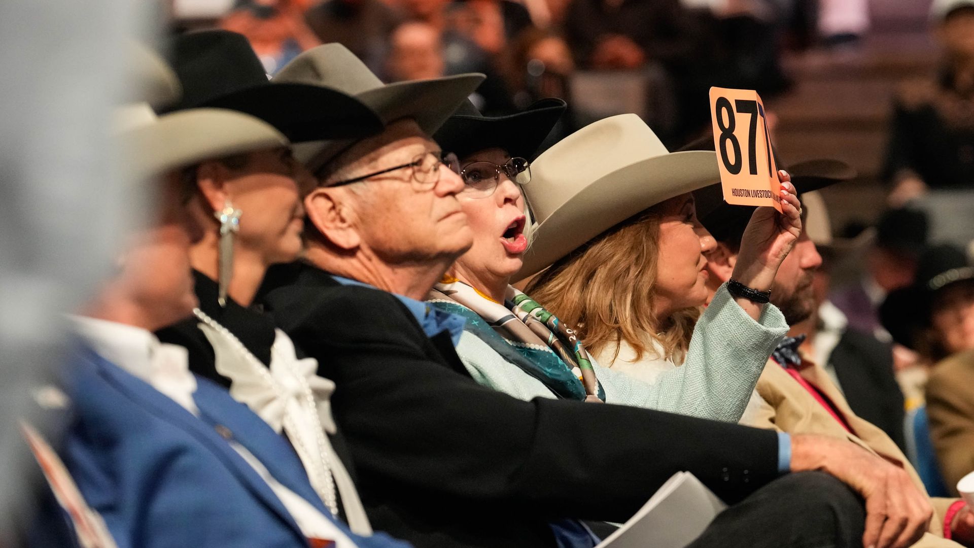 A person shouts a bid at the Rodeo Houston student art auction