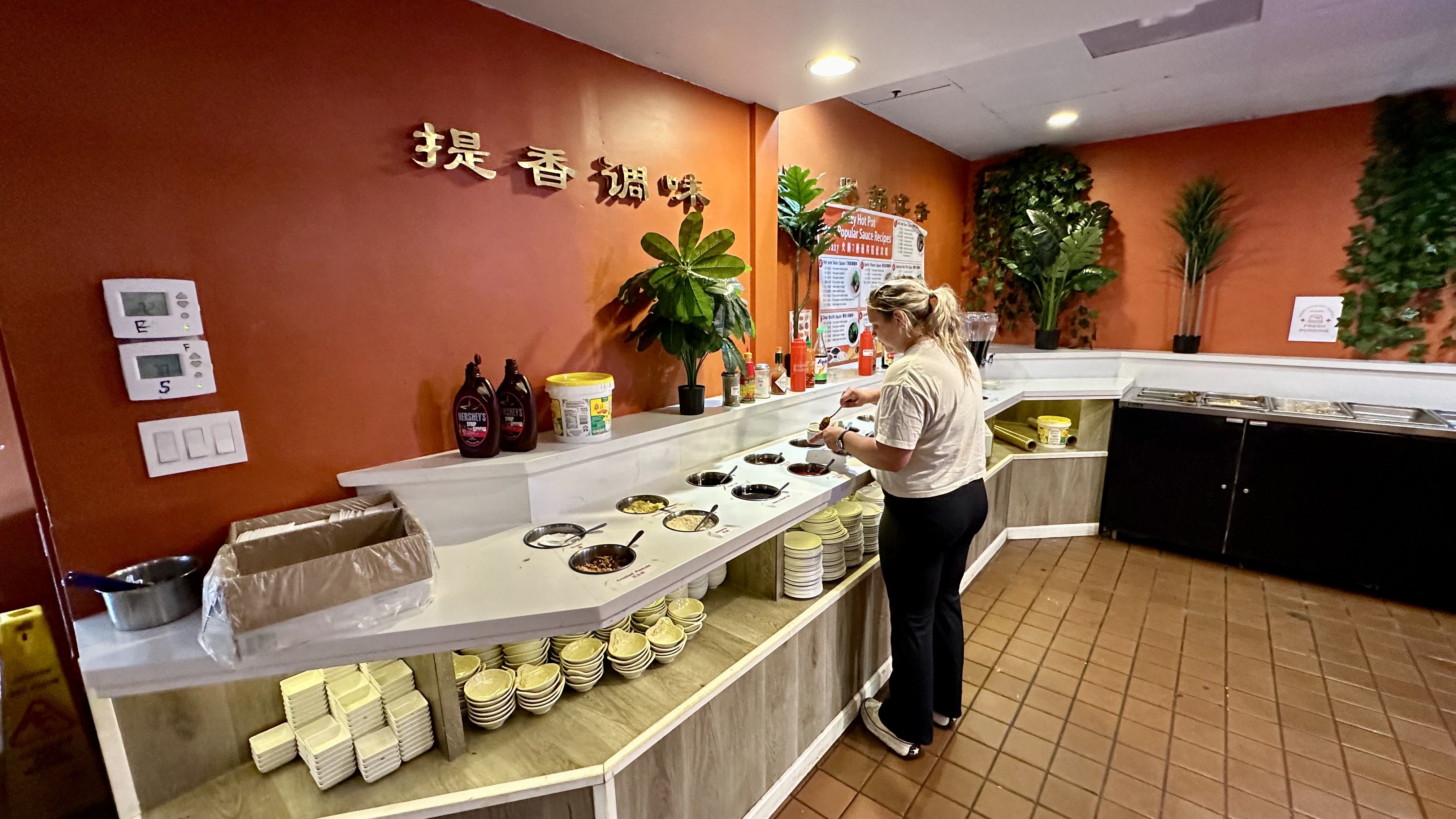 Photo shows a woman making sauce at Crazy Hot Pot.