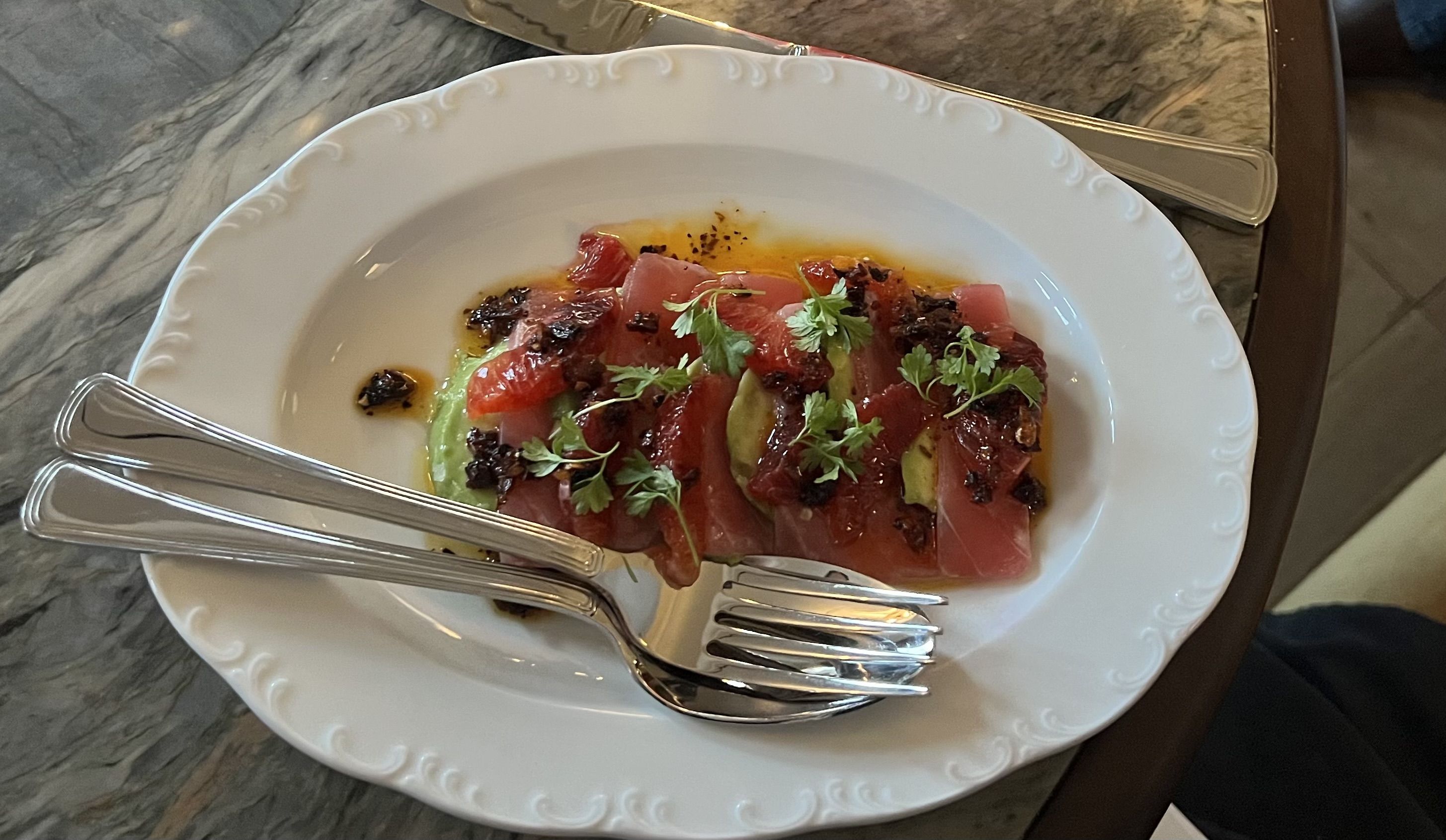 A plate with silverware across it.