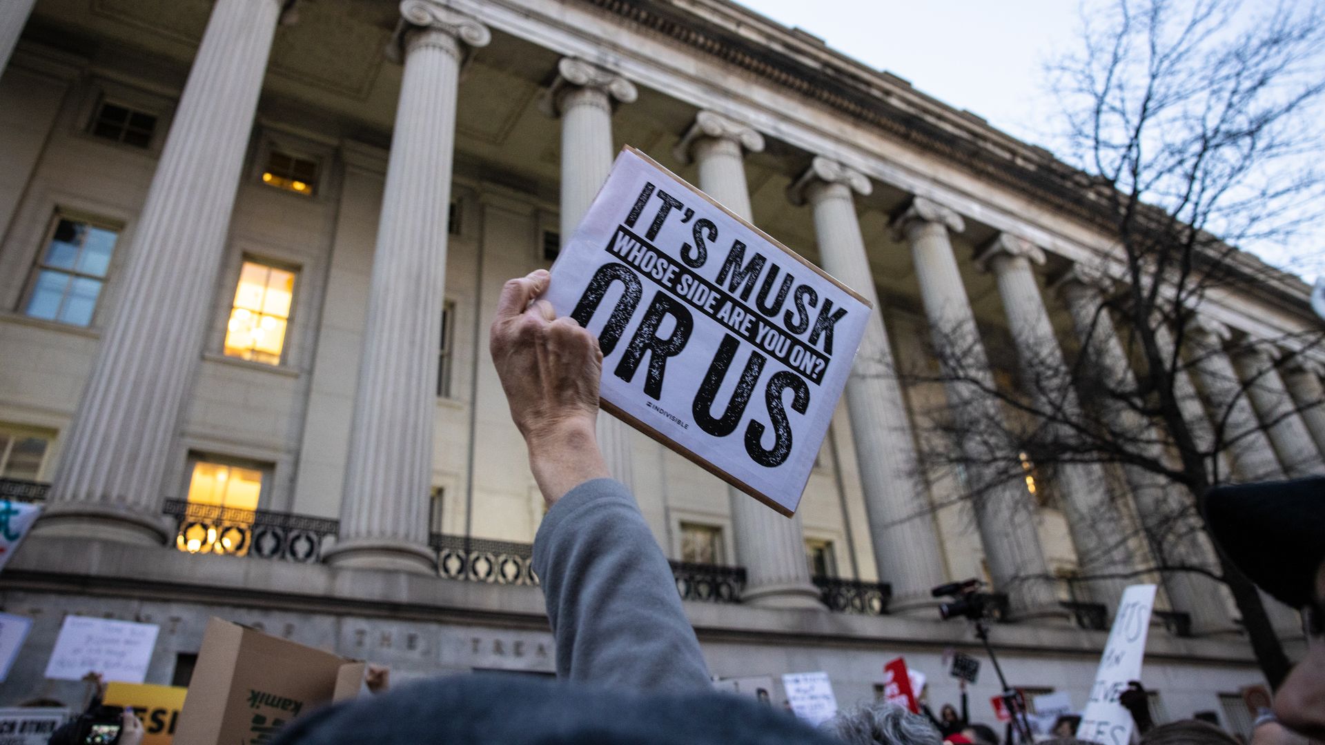 A demonstrator holds up a sign during a rally in front of the U.S. Treasury Department in protest of Elon Musk and the Department of Government Efficiency on February 4, 2025 in Washington, DC. 