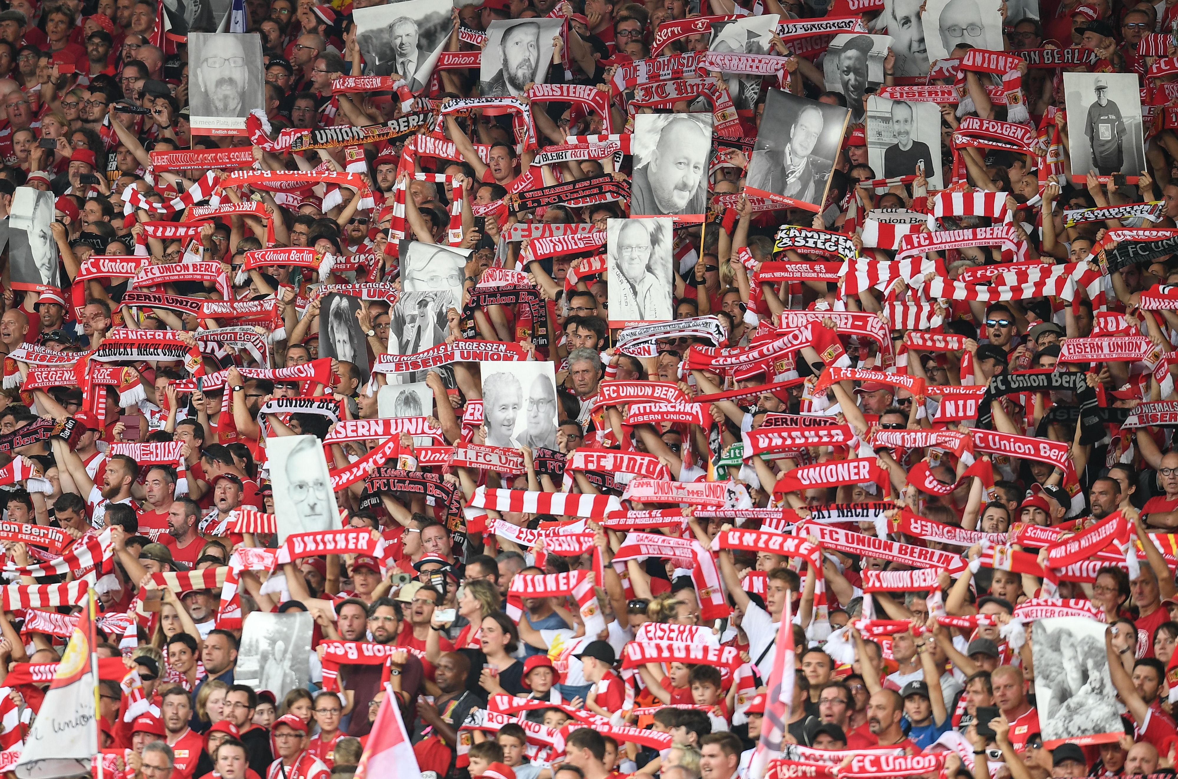 Union Berlin fans hold up photos of deceased supporters