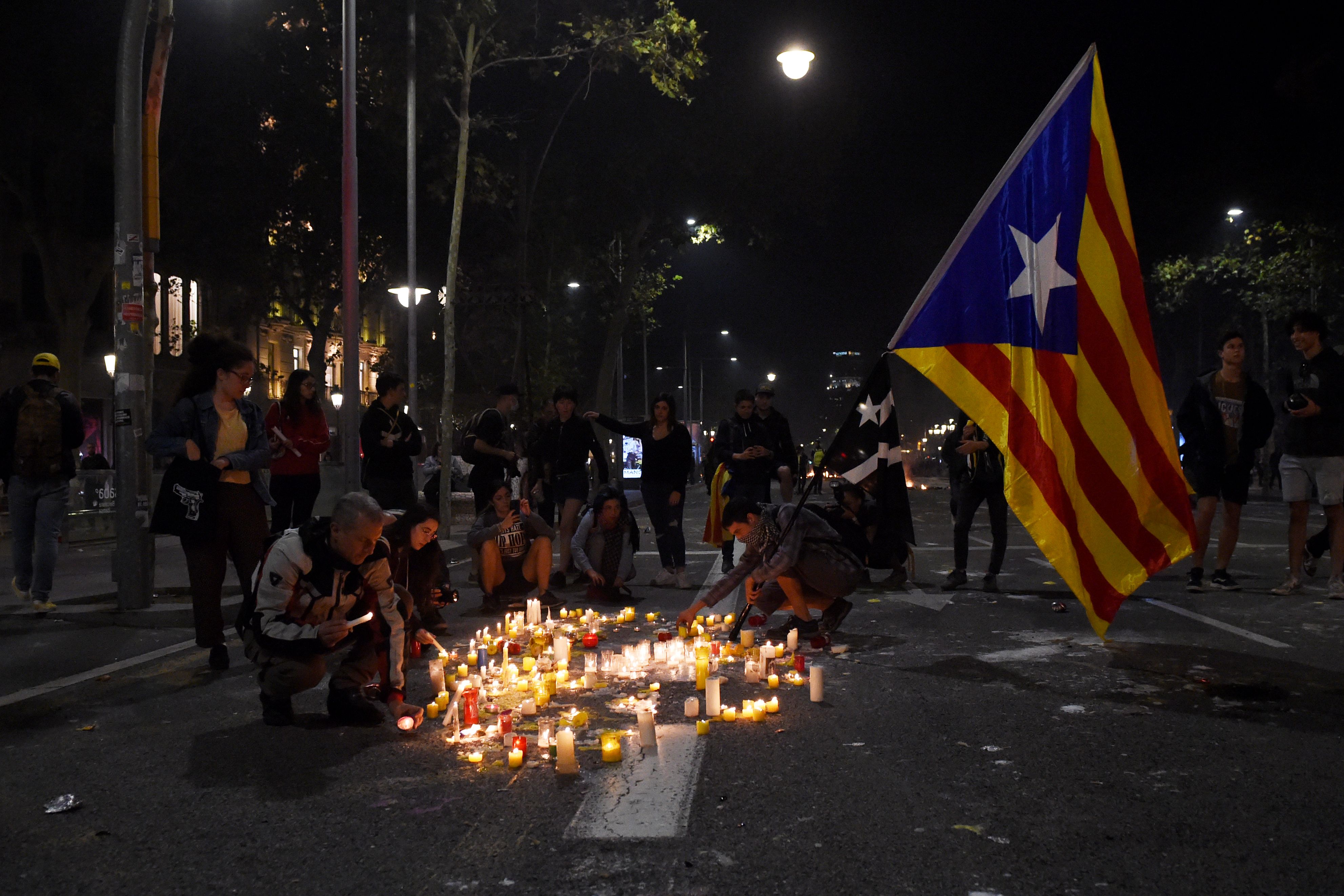  People hold a Catalan flag and light candles during a protest against the jailing of Catalan separatists in Mallorca Street near the Spanish Government Delegation on October 15, 2019 in Barcelona