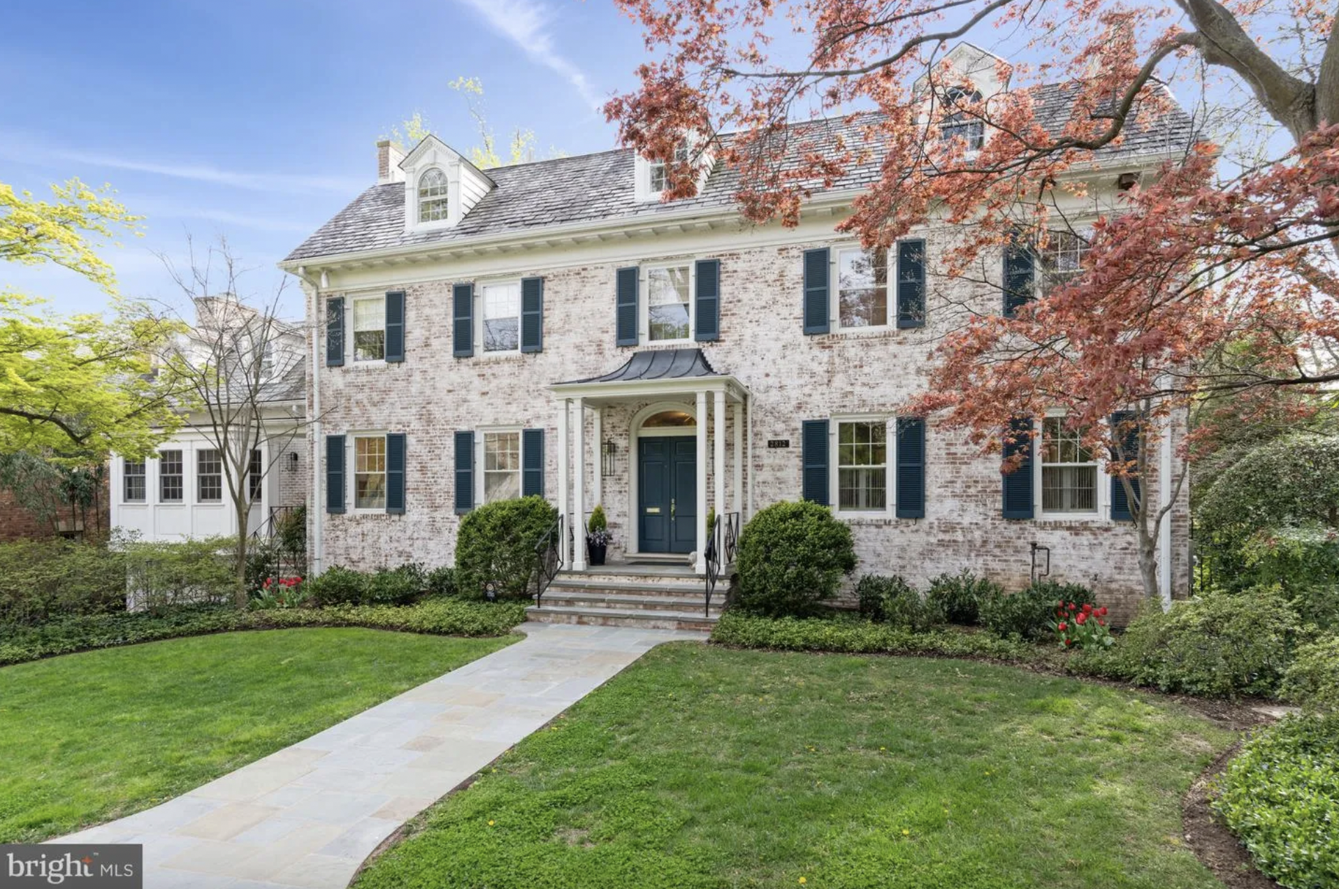 brick house with dark blue doors and shutters