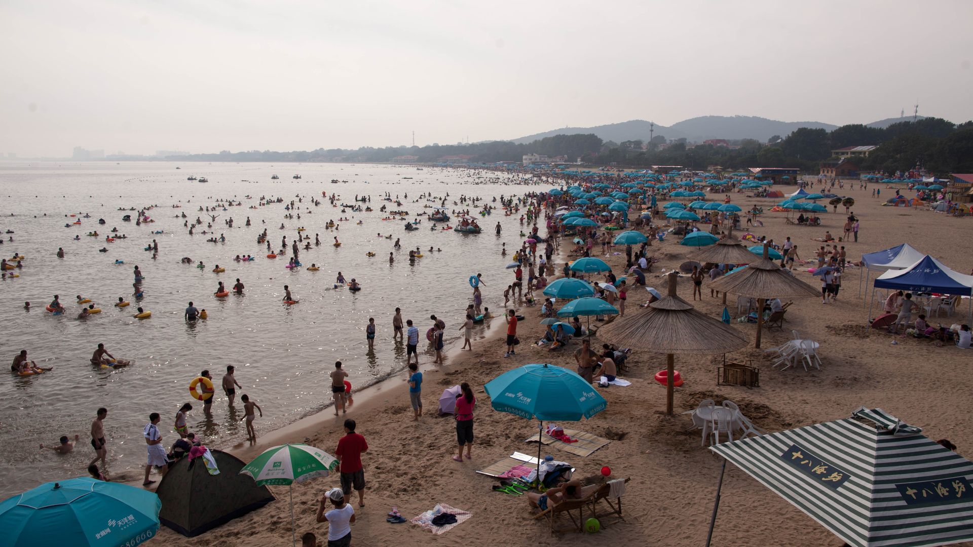 Beachgoers enjoy the seaside resort at Beidaihe in northeast China on August 6, 2012. Credit: Ed Jones/AFP/GettyImages.