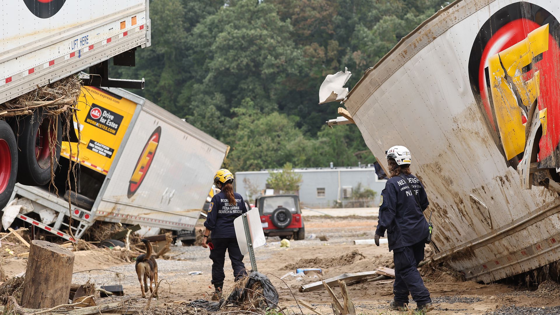 Members of the FEMA Urban Search and Rescue Task Force search a flood damaged area with a search canine in the aftermath of Hurricane Helene along the Swannanoa River on October 4, 2024 in Asheville, North Carolina. 