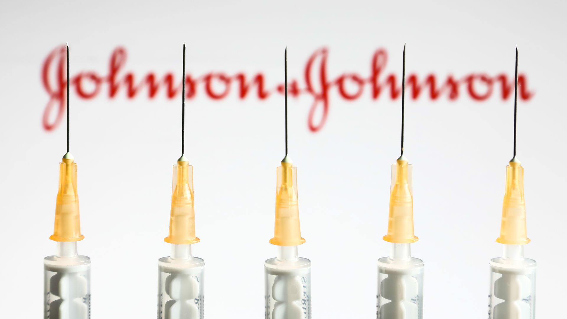 PICTURE of syringes in front of a johnson & johnson logo