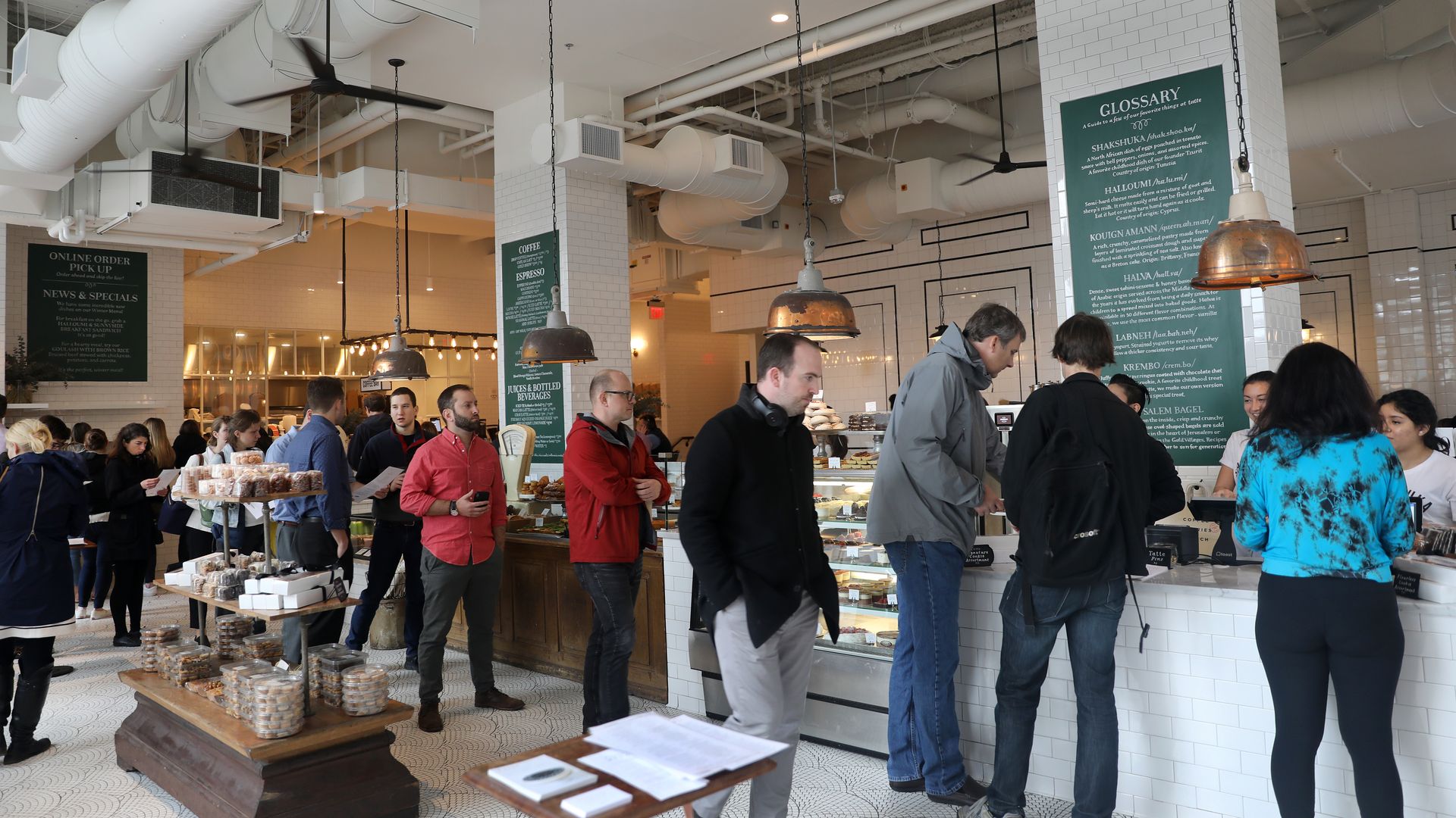 People wait in line inside a Tatte Bakery & Cafe in Boston.