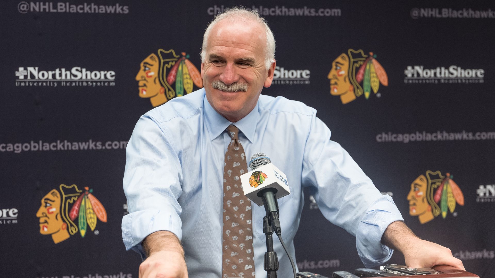 Photo of a man smiling behind a podium. 