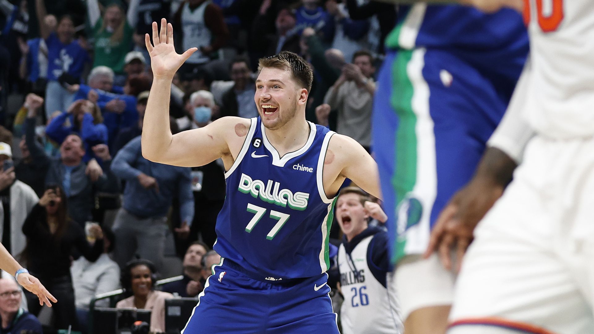 Luka Doncic of the Dallas Mavericks waves and smiles while on the court