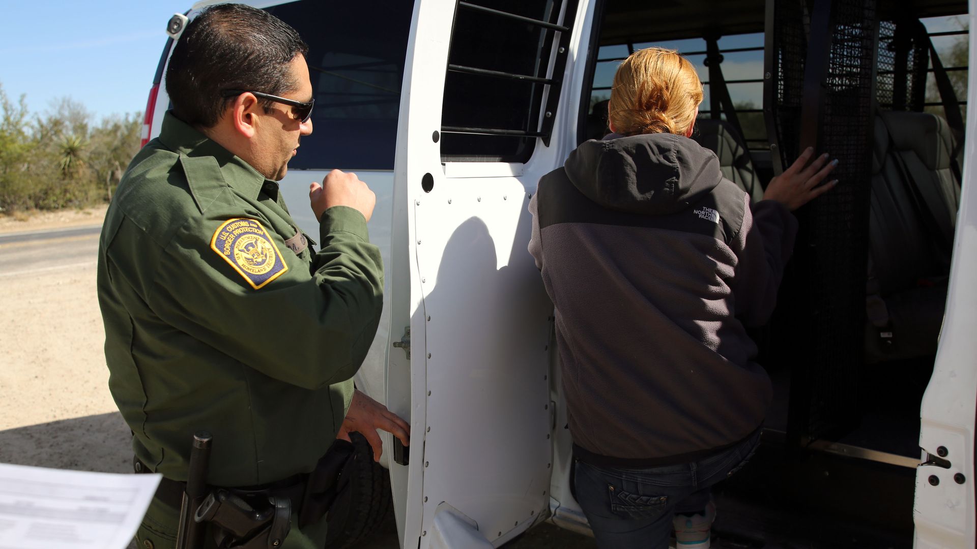 A Border Patrol agent transfers a Honduran woman who illegally crossed the Rio Grande River in south Texas to be transported for further processing.  Getty Images 
