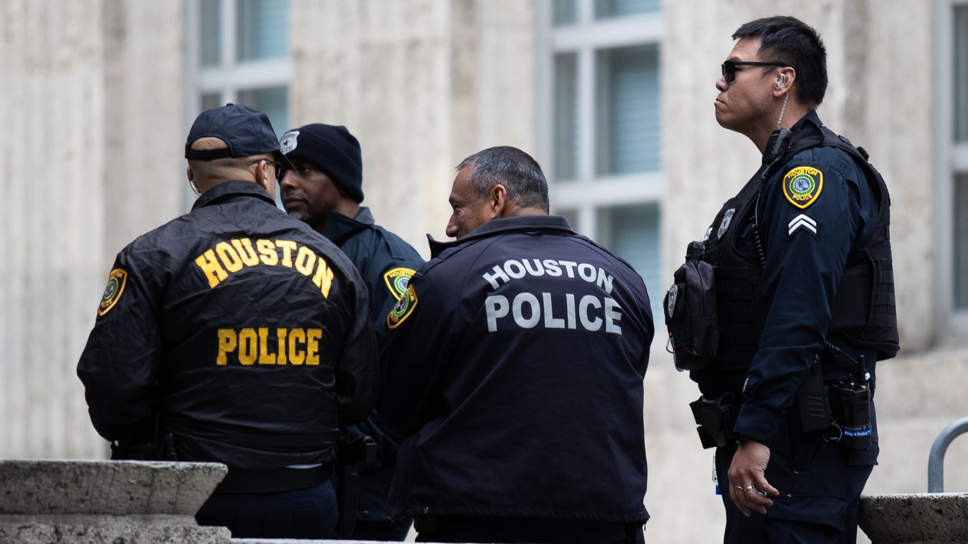 A group of Houston police officers with City Hall in the background