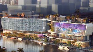 A rendering of a sleek, modern, glass-fronted hotel along a river. 