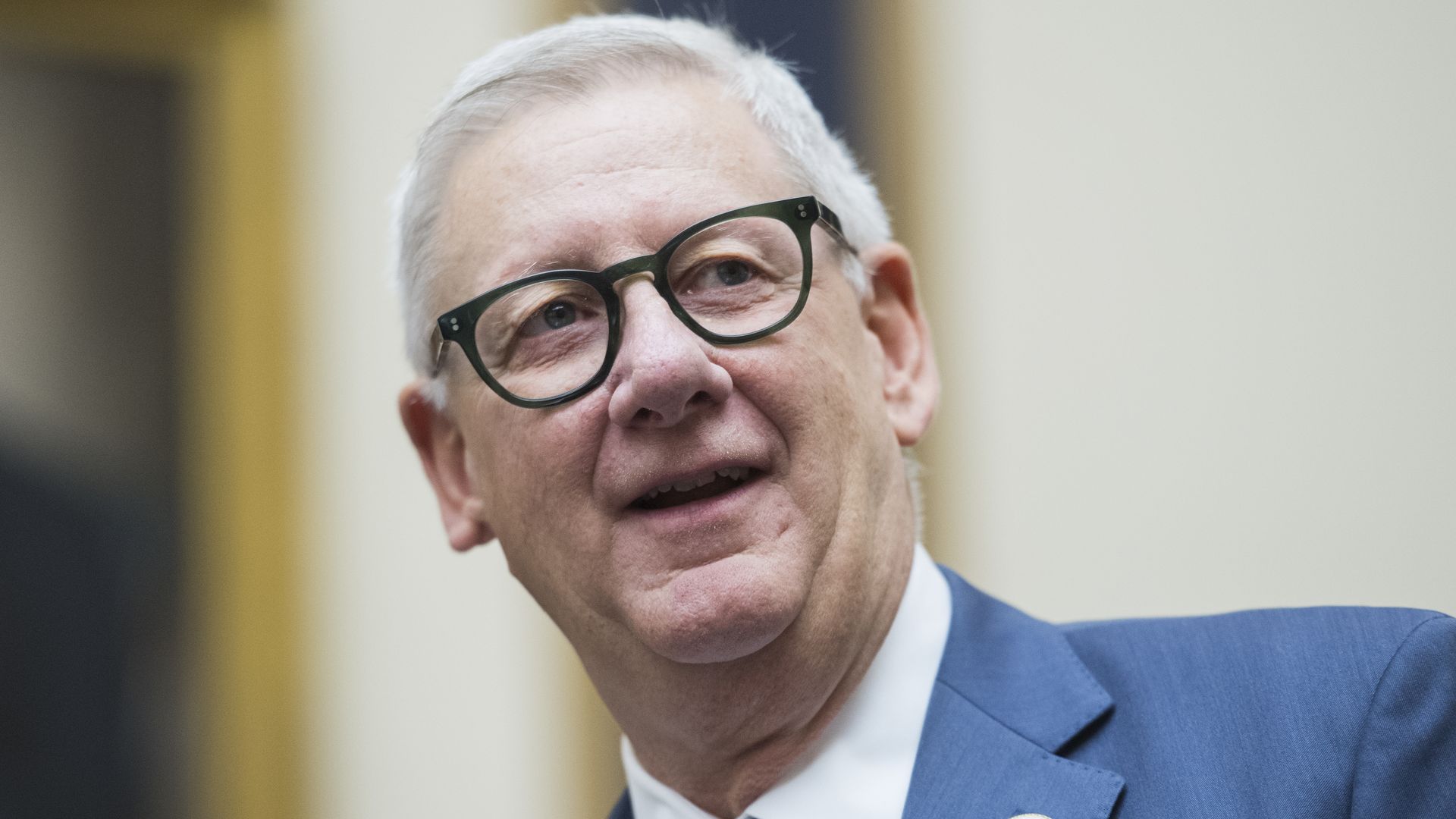 Rep. Paul Mitchell wearing a suit and tie and black glasses