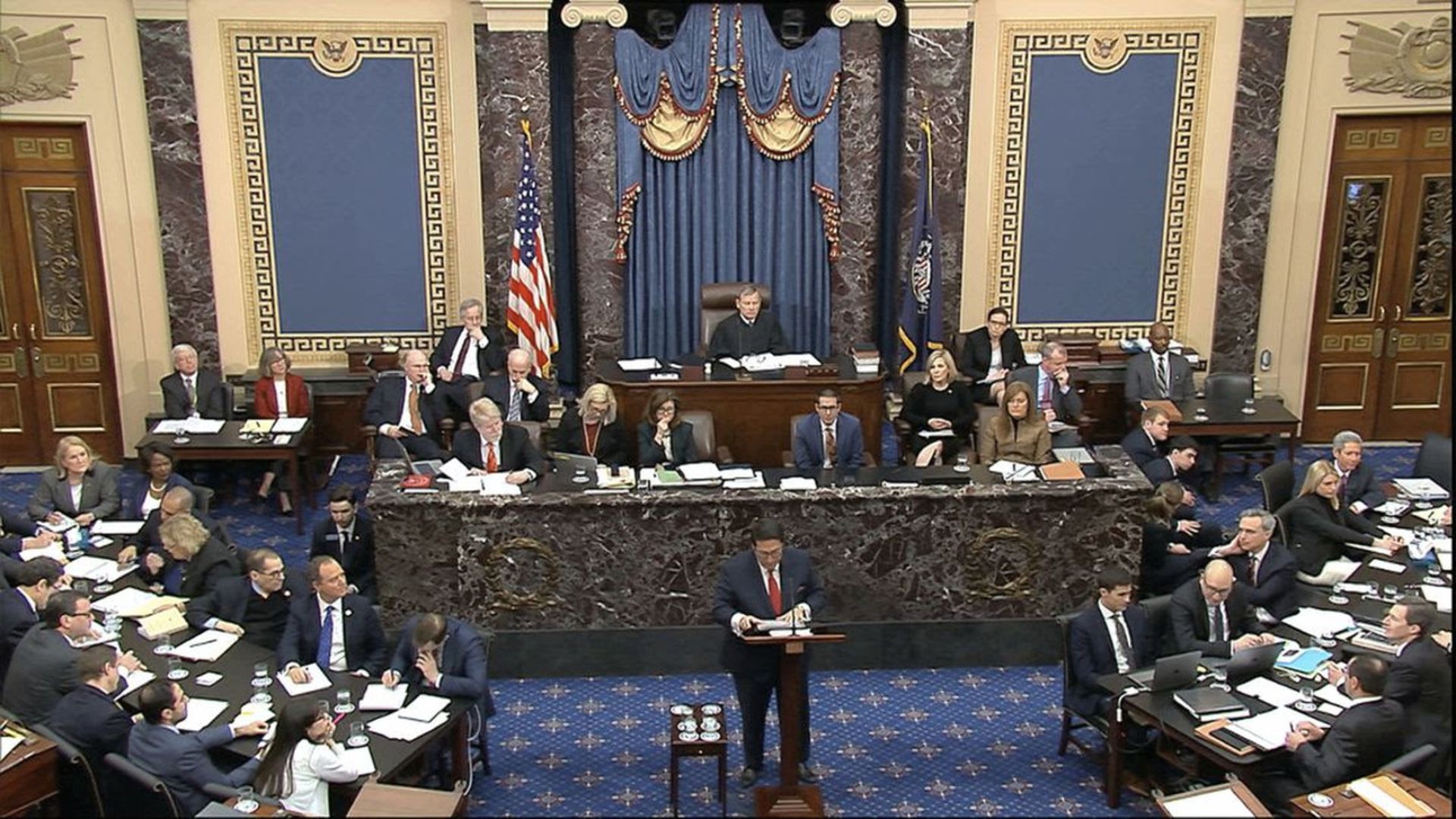 Trump attorney Jay Sekulow holds the Mueller report as Rep. Adam Schiff and other impeachment managers listen. Photo: Senate TV via AP