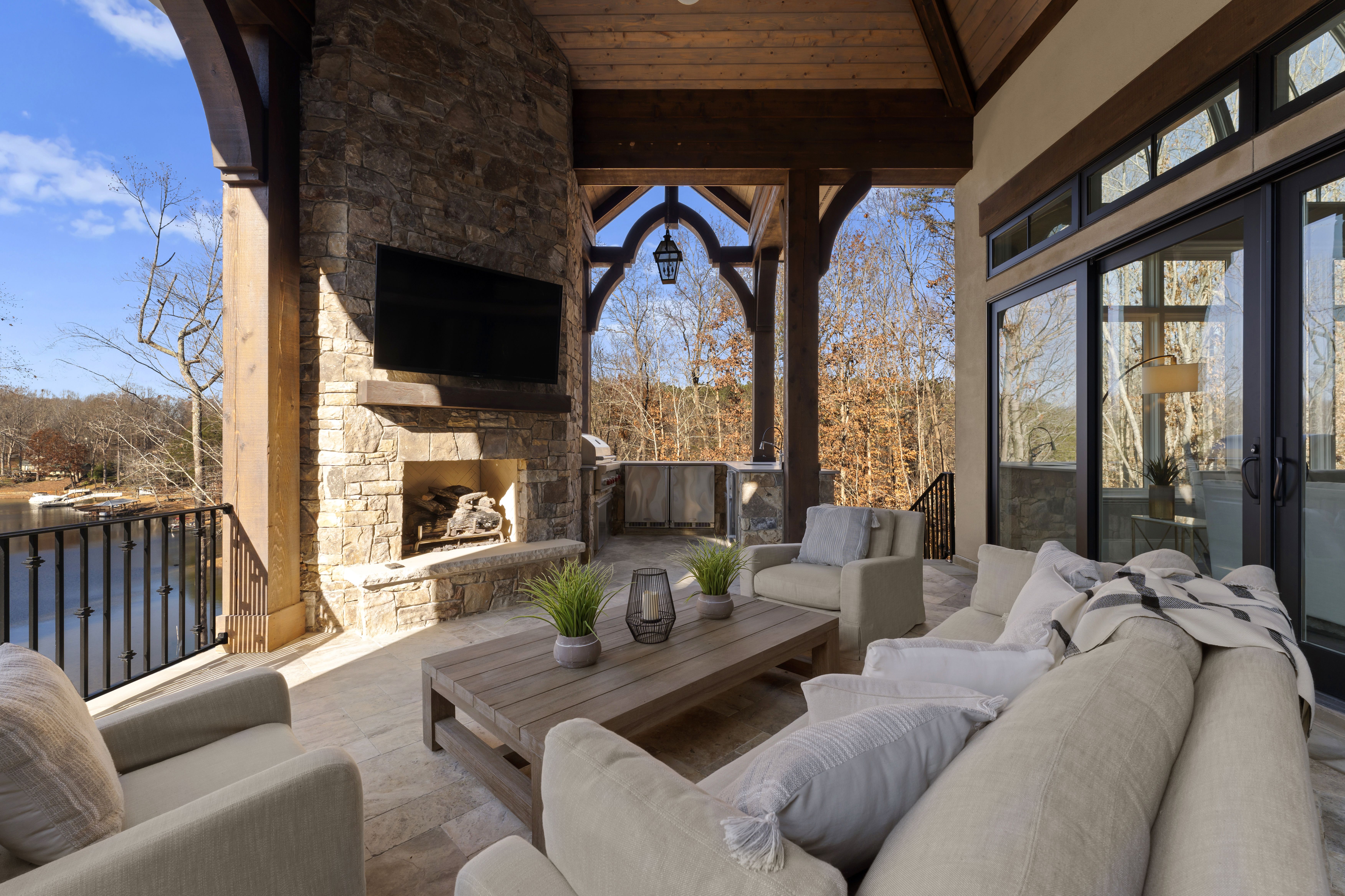 outdoor living room with a fireplace overlooking a lake