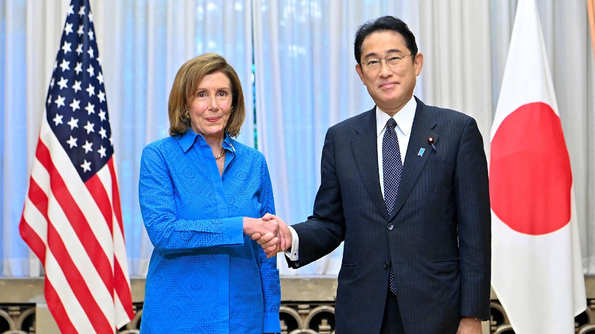 House Speaker Nancy Pelosi (L) shakes hands with Japanese Prime Minister Fumio Kishida during a meeting at the prime minister's official residence in Tokyo on August 5.