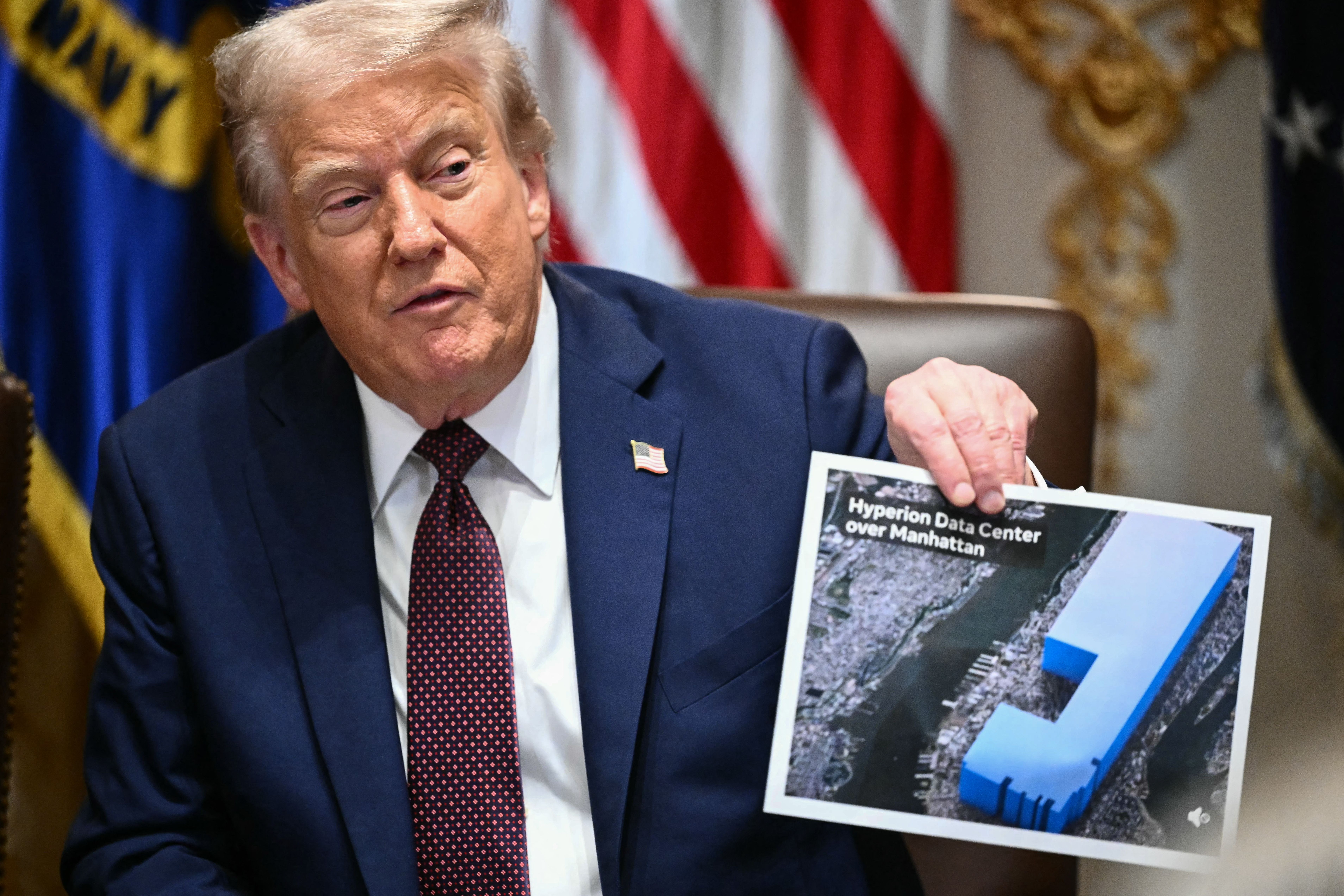  President Donald Trump holds an image showing the size of Meta's new data center, during a cabinet meeting in the Cabinet Room of the White House.
