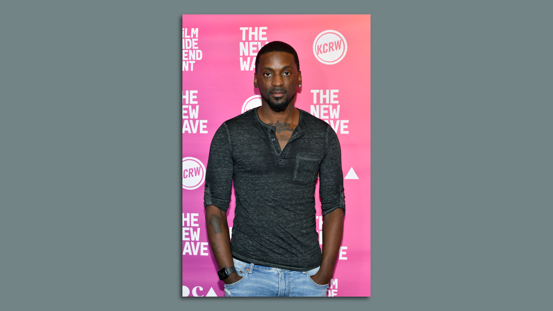 A man posing for a photo at a movie premiere.