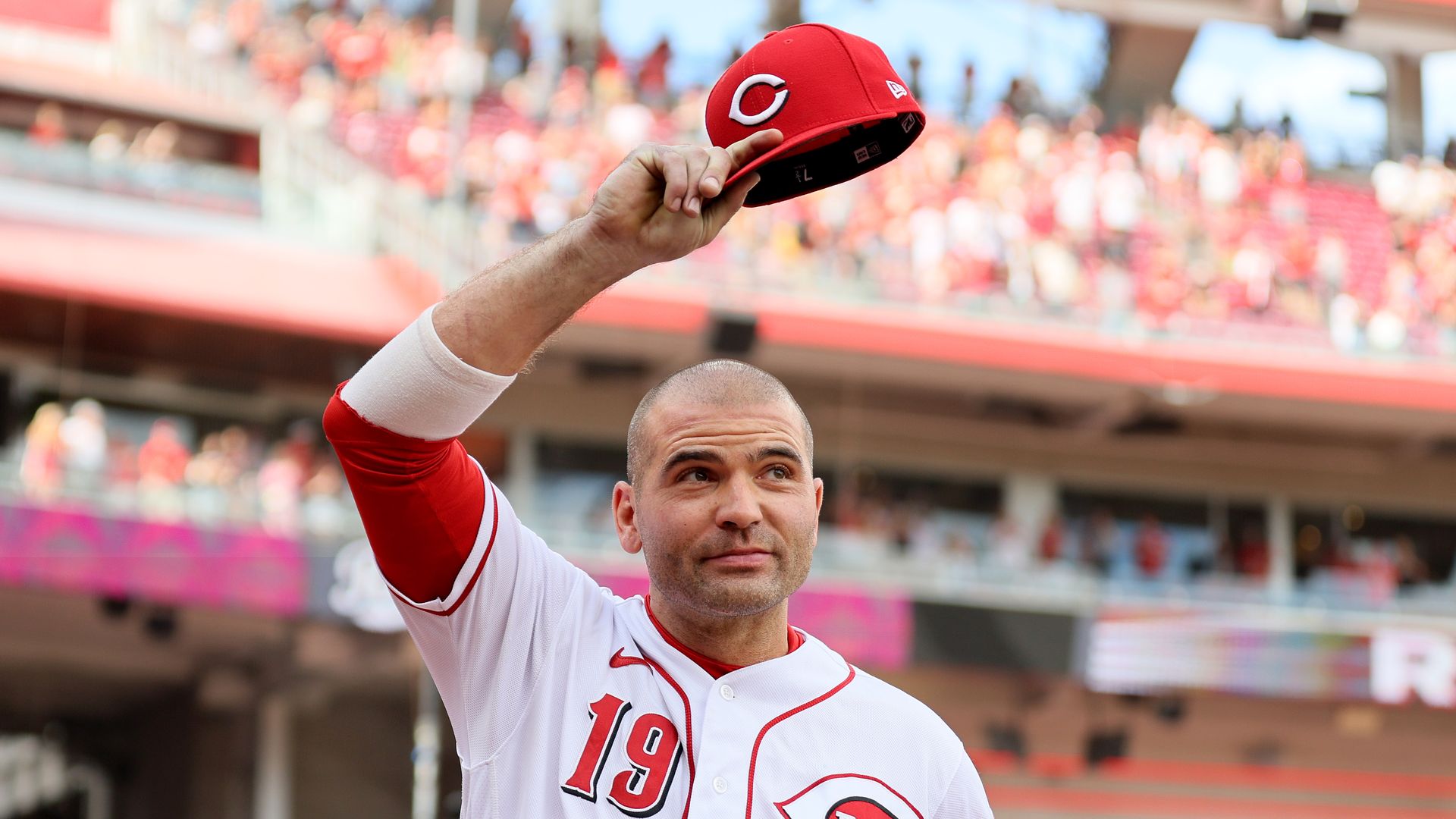 Joey Votto, wearing a white jersey #19, tips his redcap to acknowledge the Cincinnati Reds fans at Great American Ball Park in Cincinnati, in September 2023. (Photo by Andy Lyons/Getty Images)