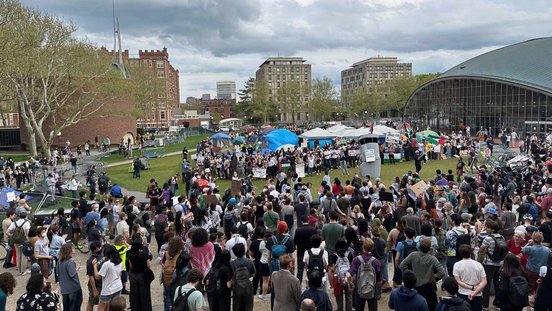 Student protesters sit around the encampment at MIT after tearing down the fence blocking it off, defying the college president's order to clear the site. 