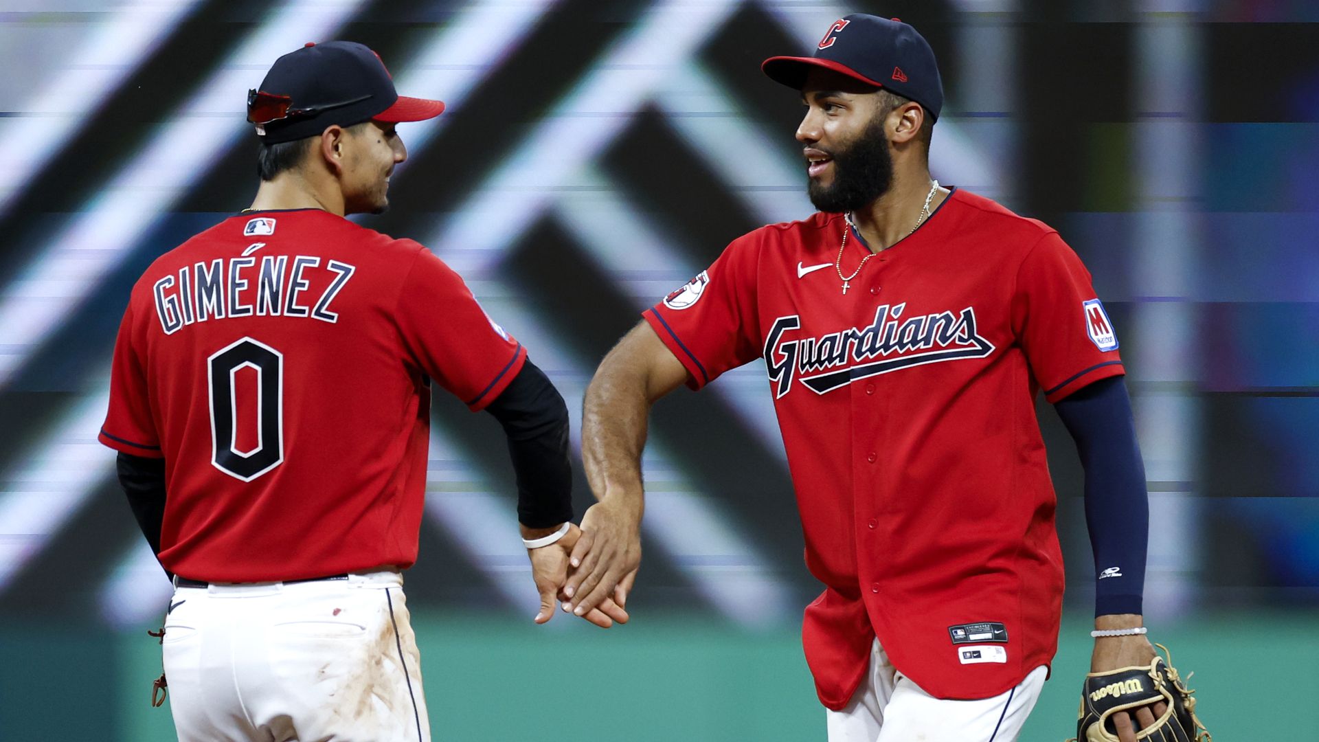 Two members of the Cleveland Guardians low-five.