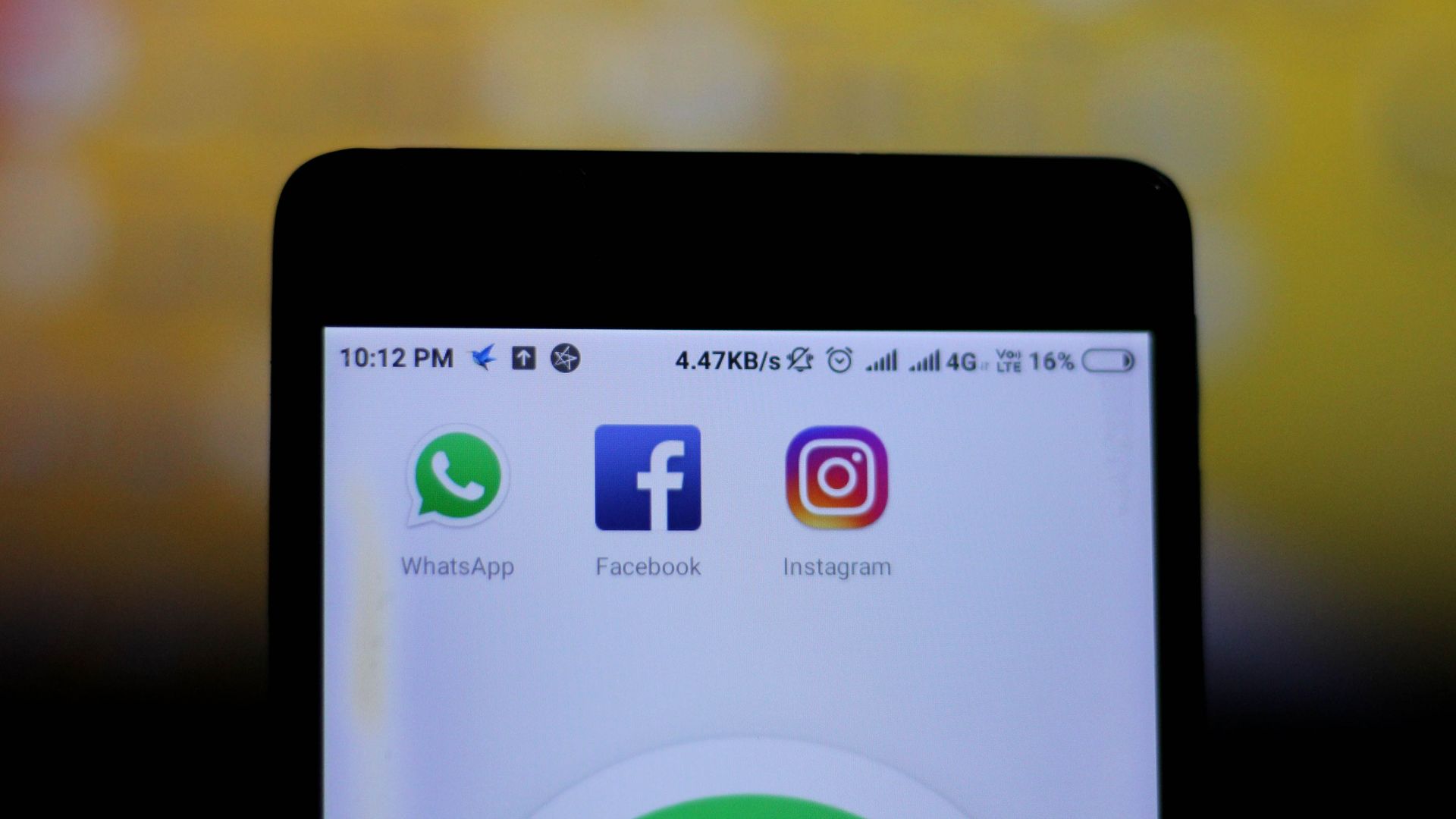 In this image, someone holds a phone up to the camera and three apps are displayed: WhatsApp, Facebook, and Instagram.
