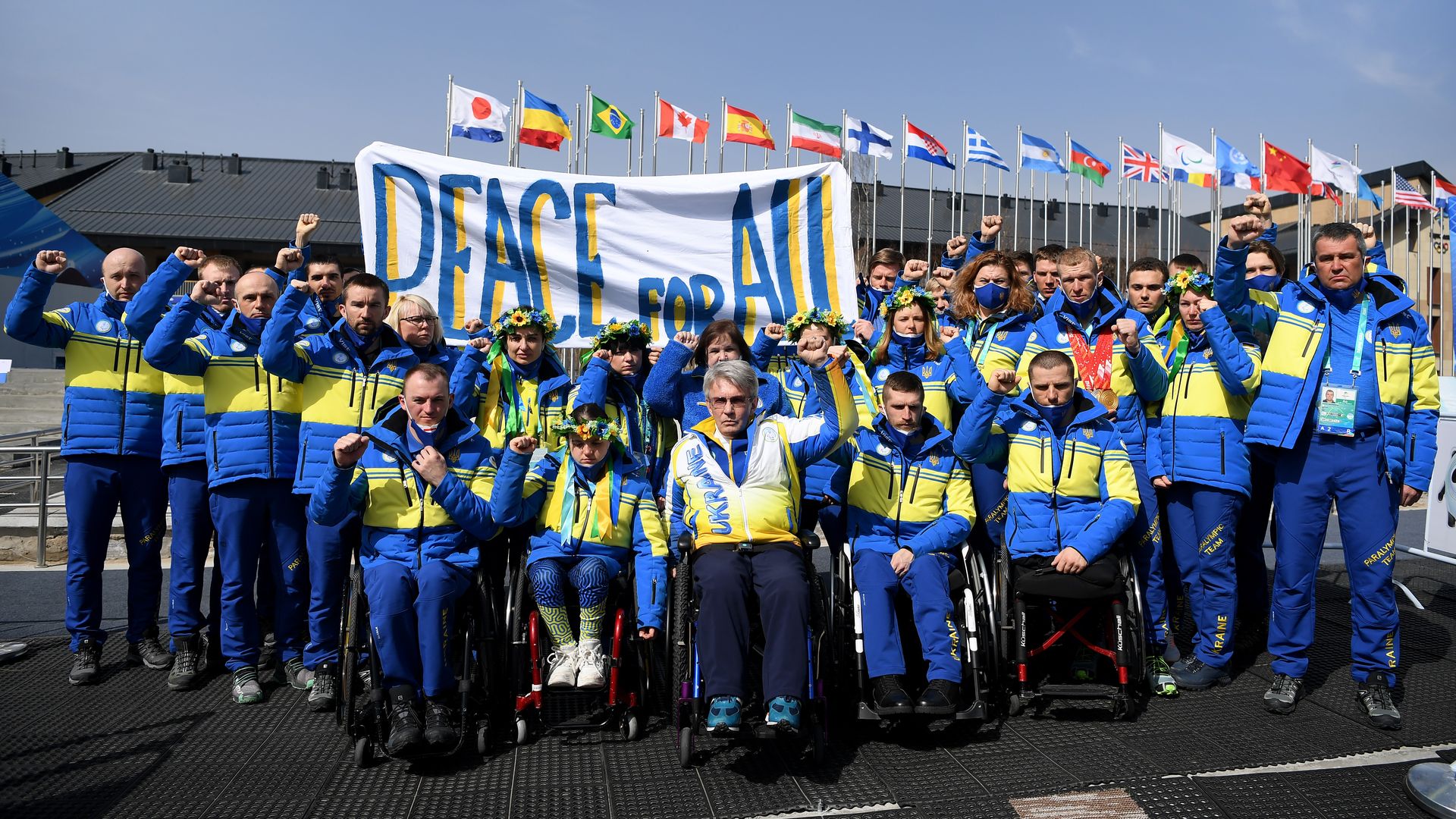 Ukraine Paralympic Committee holding a Peace for All sign with raised fists underneath