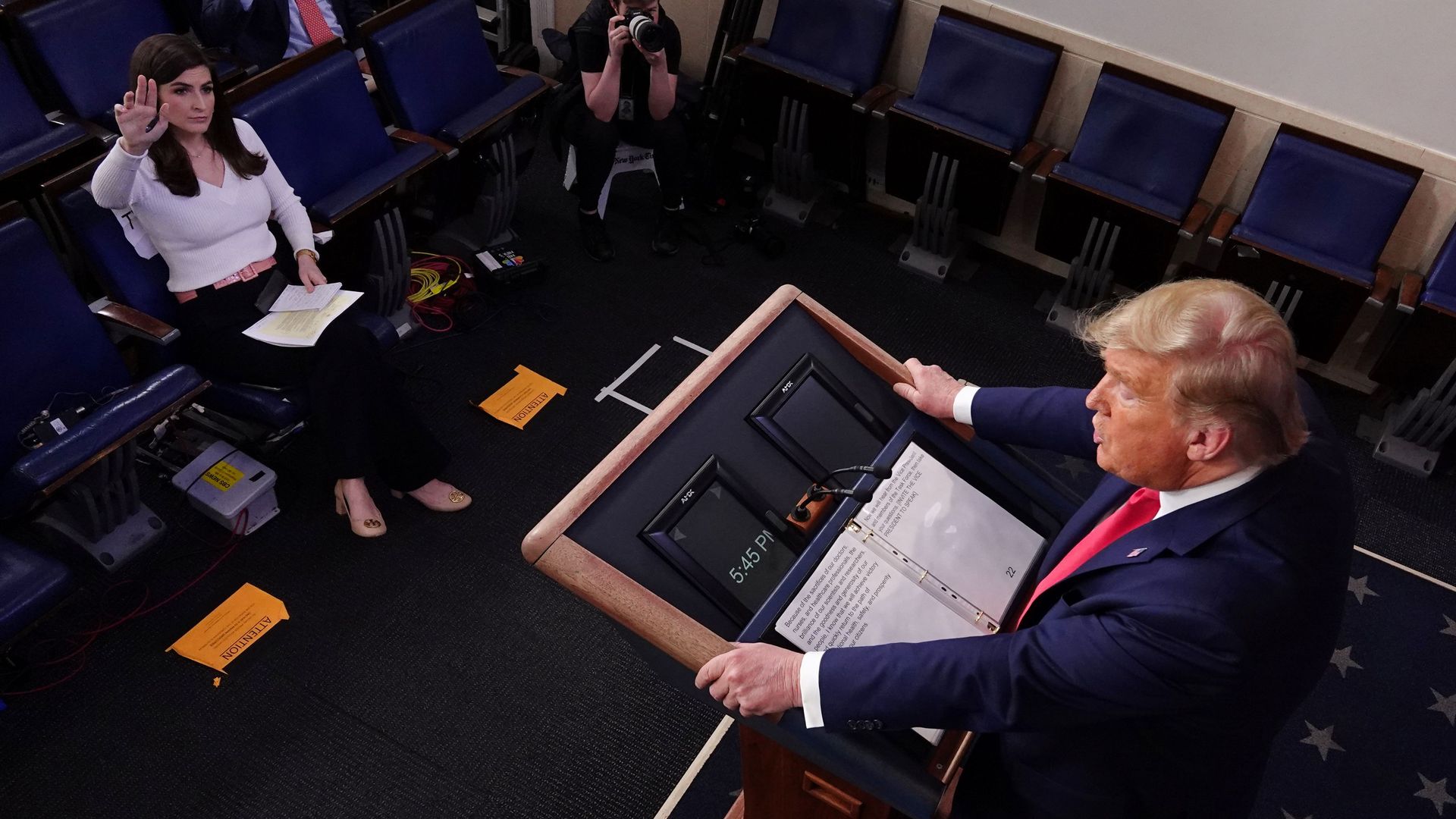 A CNN reporter raising her hand to ask Trump a coronavirus question