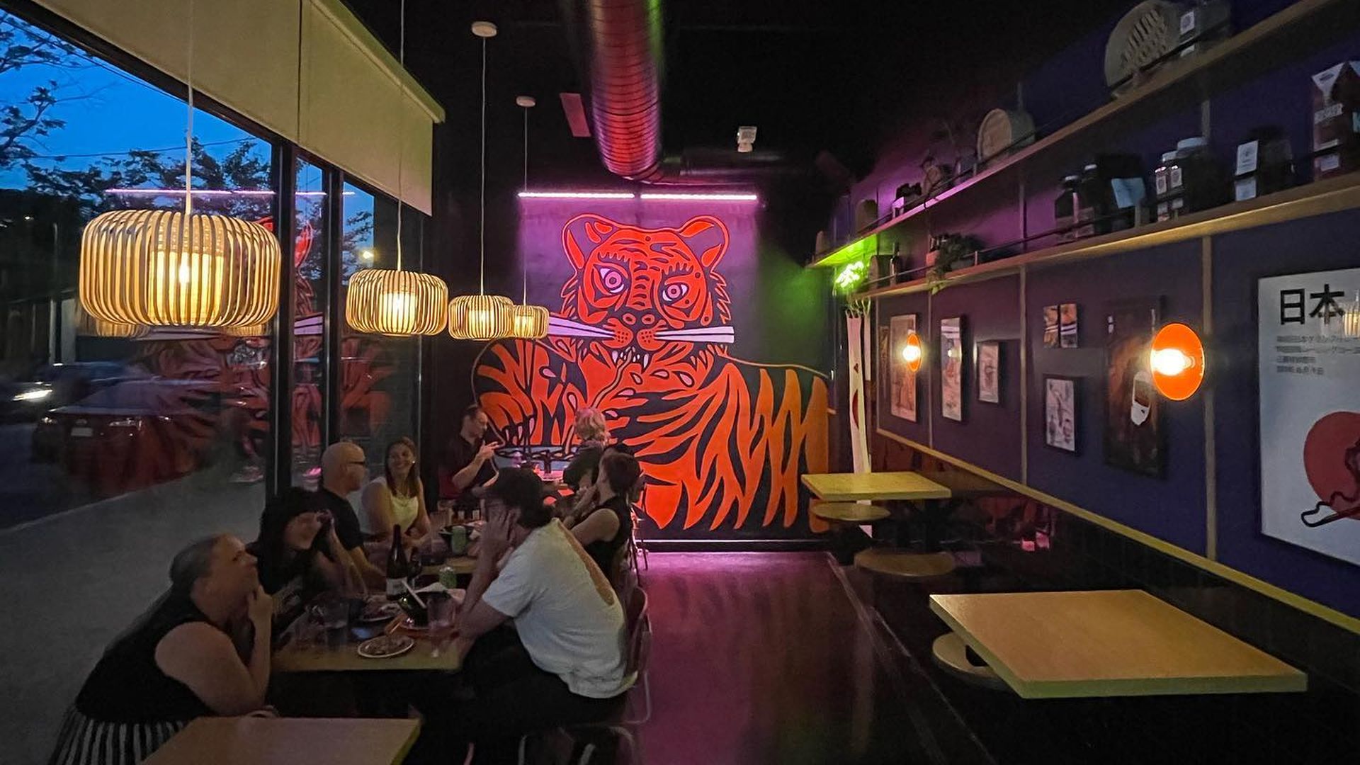 a big tiger mural inside a funky looking restaurant 