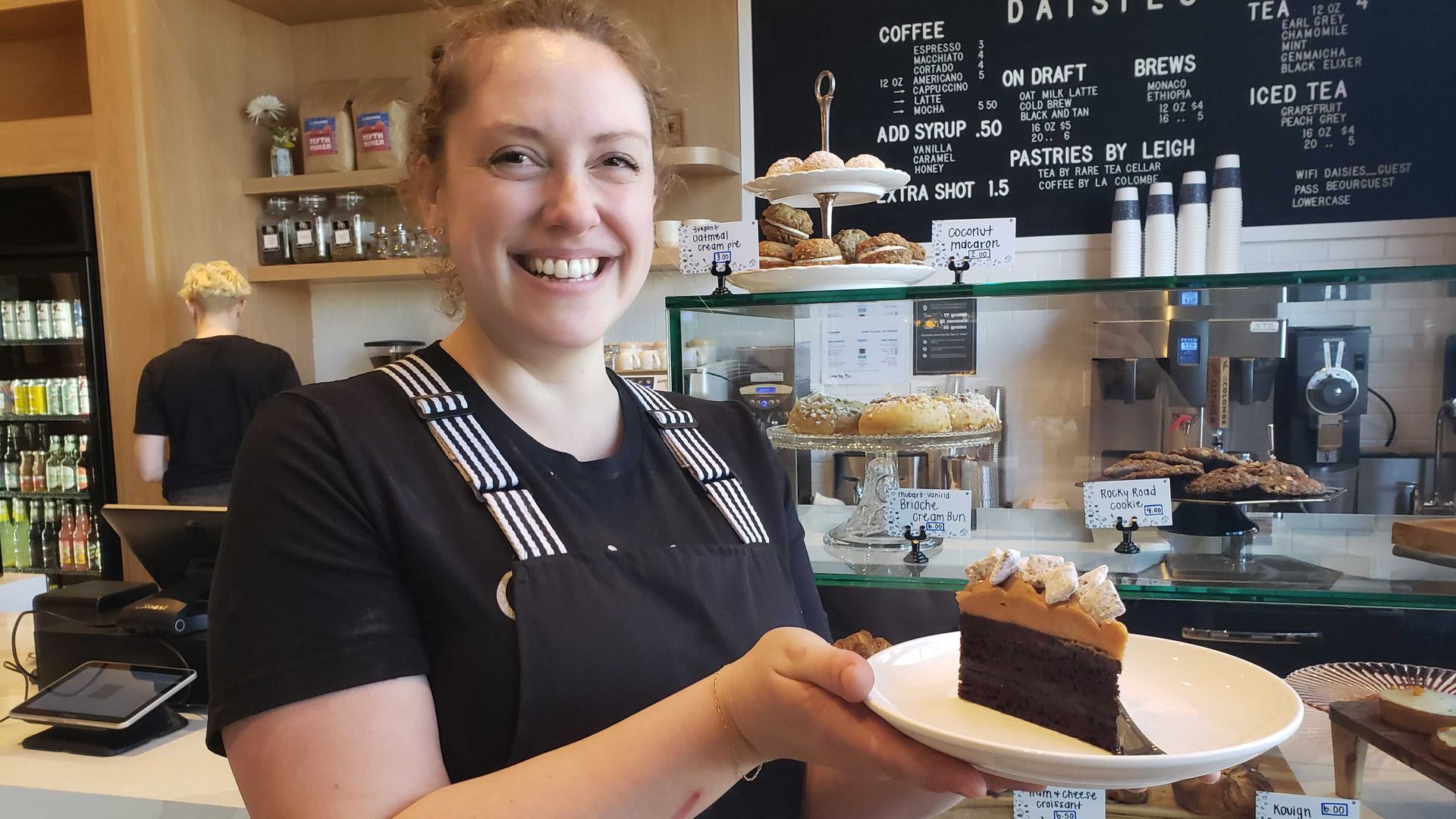 Photo of a woman holding a plate of cake. 