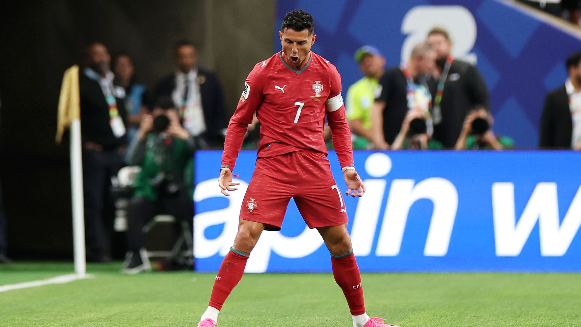Man in red soccer attire in number 7 celebrating. 