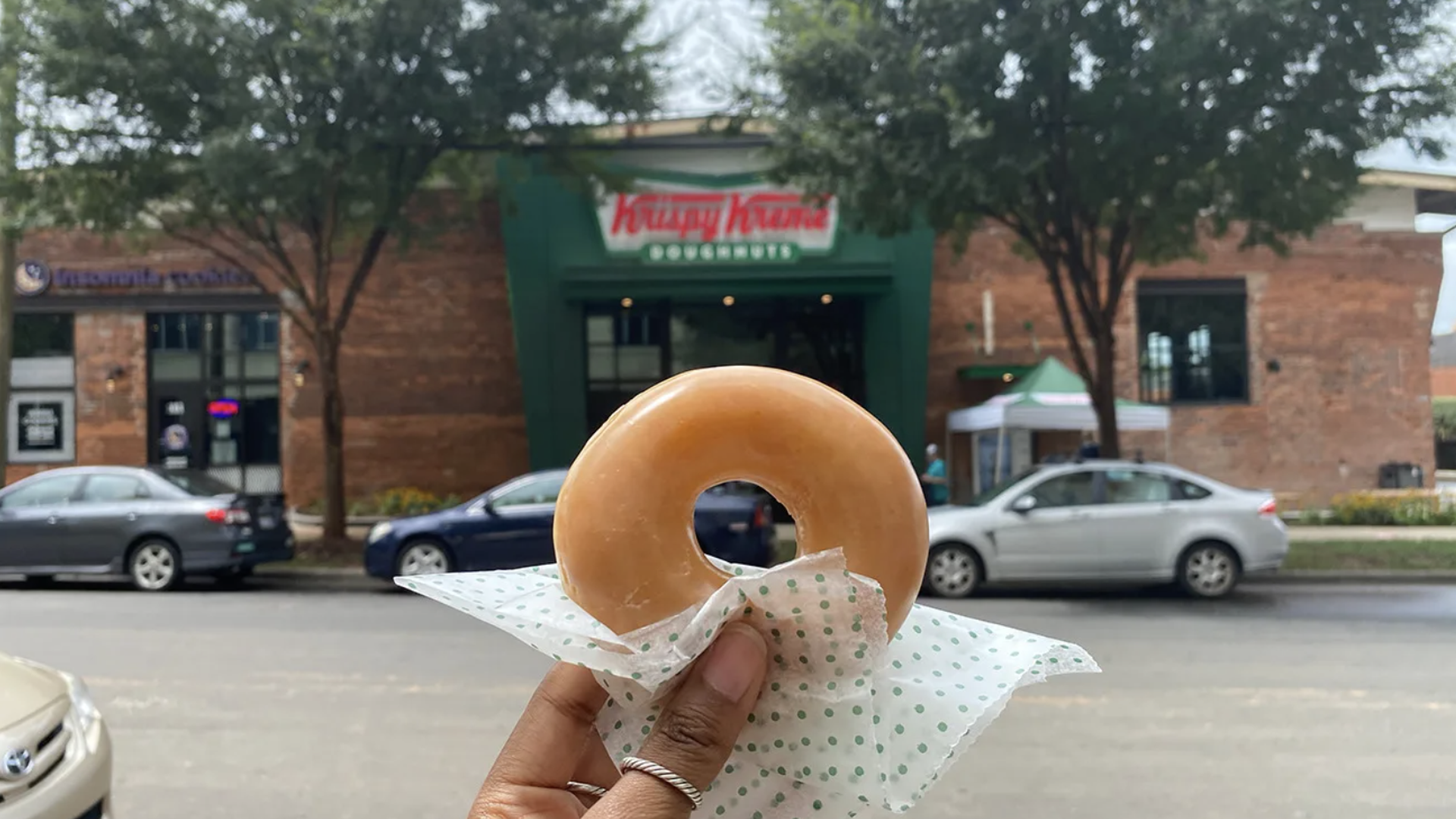 donut from krispy kreme held up in front of the south end lcoation