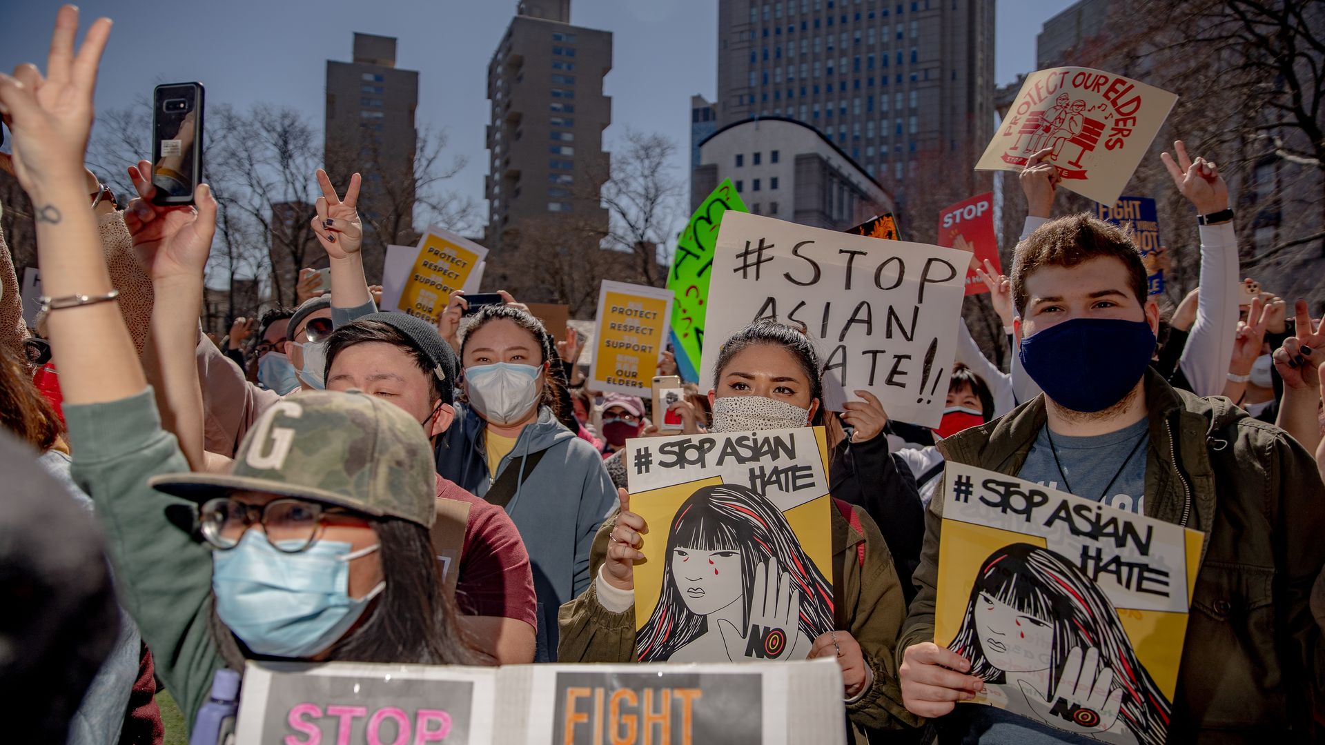Demonstrators hold signs during an AAPI Rally Against Hate in New York, U.S., on Sunday, March 21