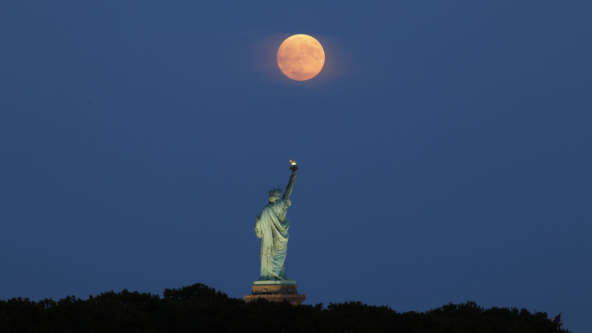 Statue of Liberty on dark background with orange moon