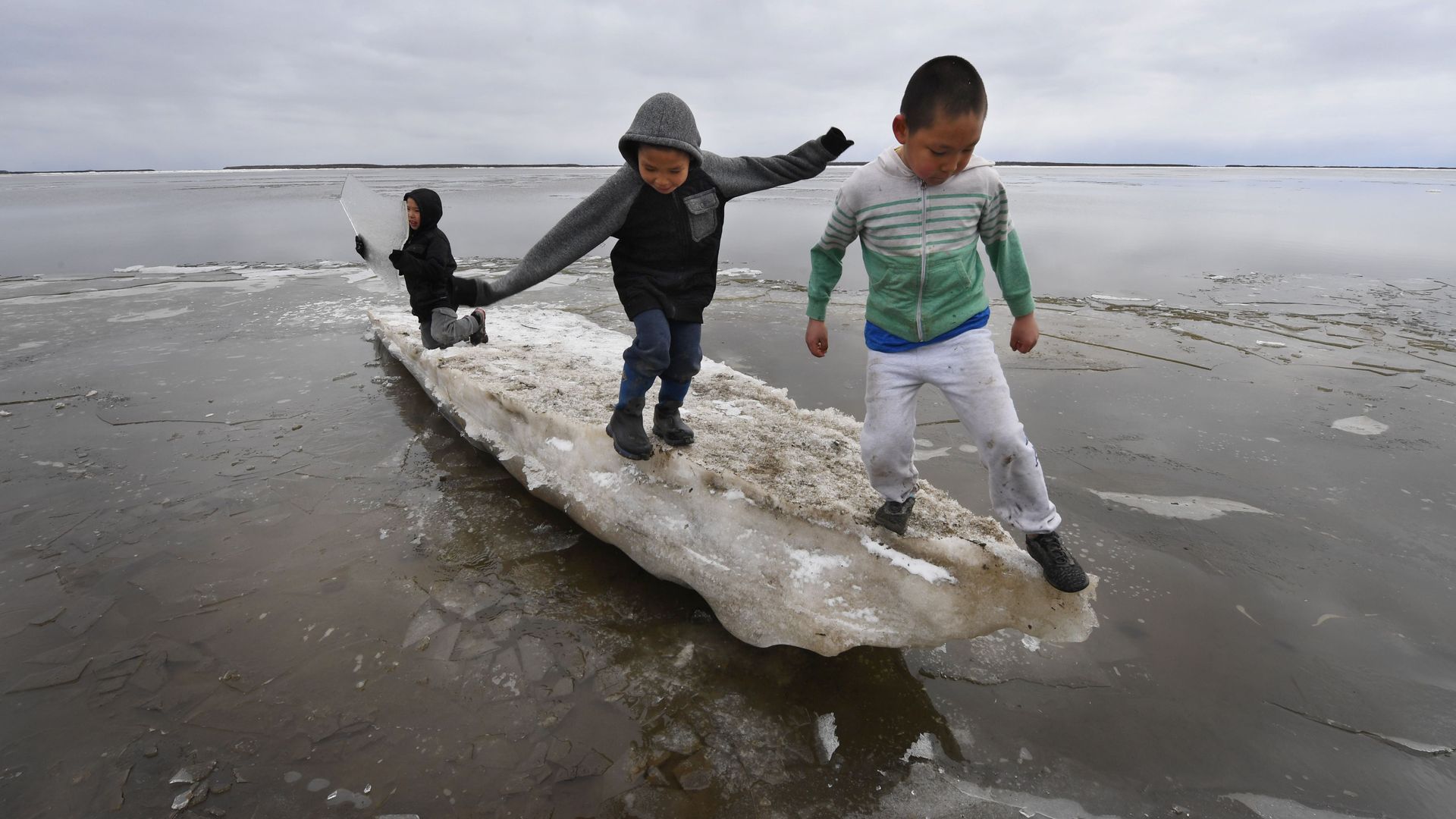 Schoolchildren play on melting ice at the climate change affected Yupik Eskimo village of Napakiak on the Yukon Delta in Alaska on April 18, 2019. 