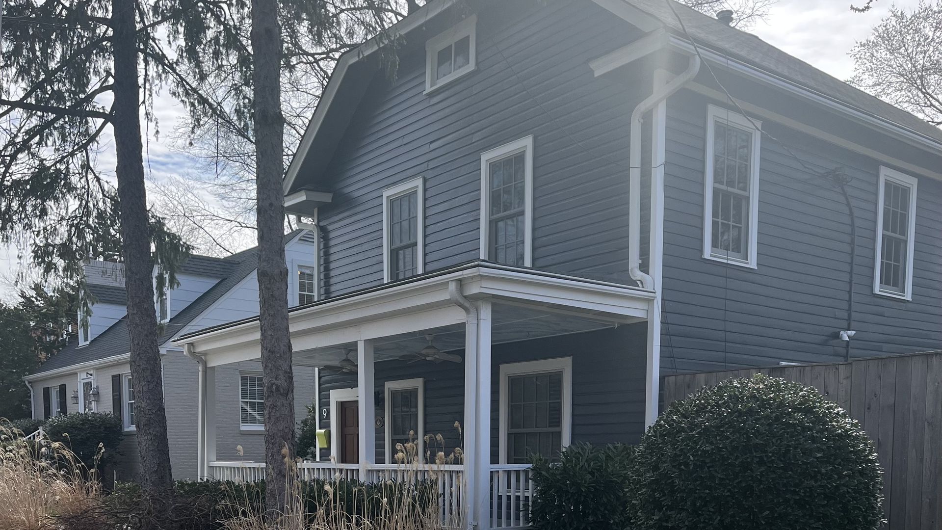 A photo of a blue house with a porch.